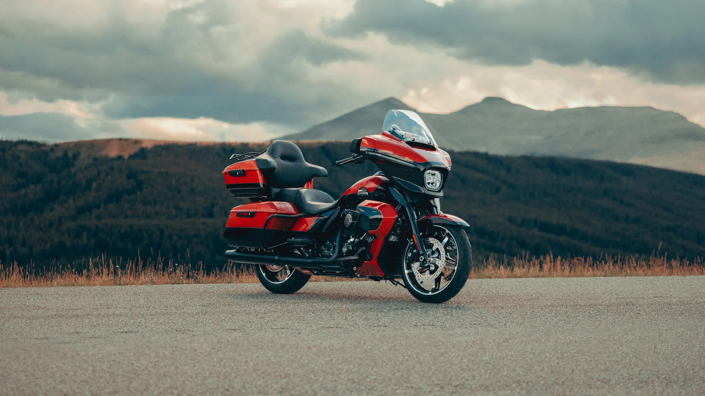 2025 Harley-Davidson® Street Glide® Ultra parked roadside with forested mountains in the background