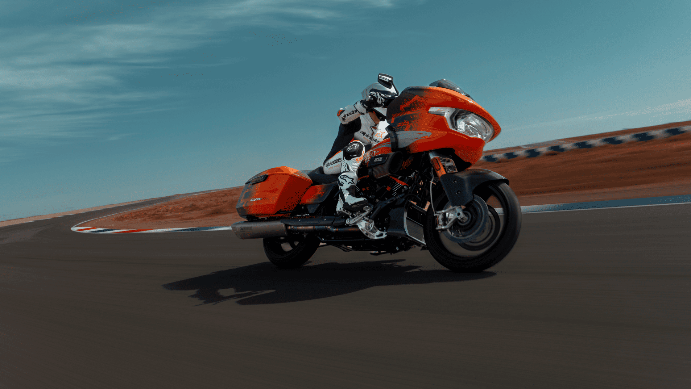 2025 Harley-Davidson® CVO™ Road Glide® RR in orange racing on a track with rider in full gear