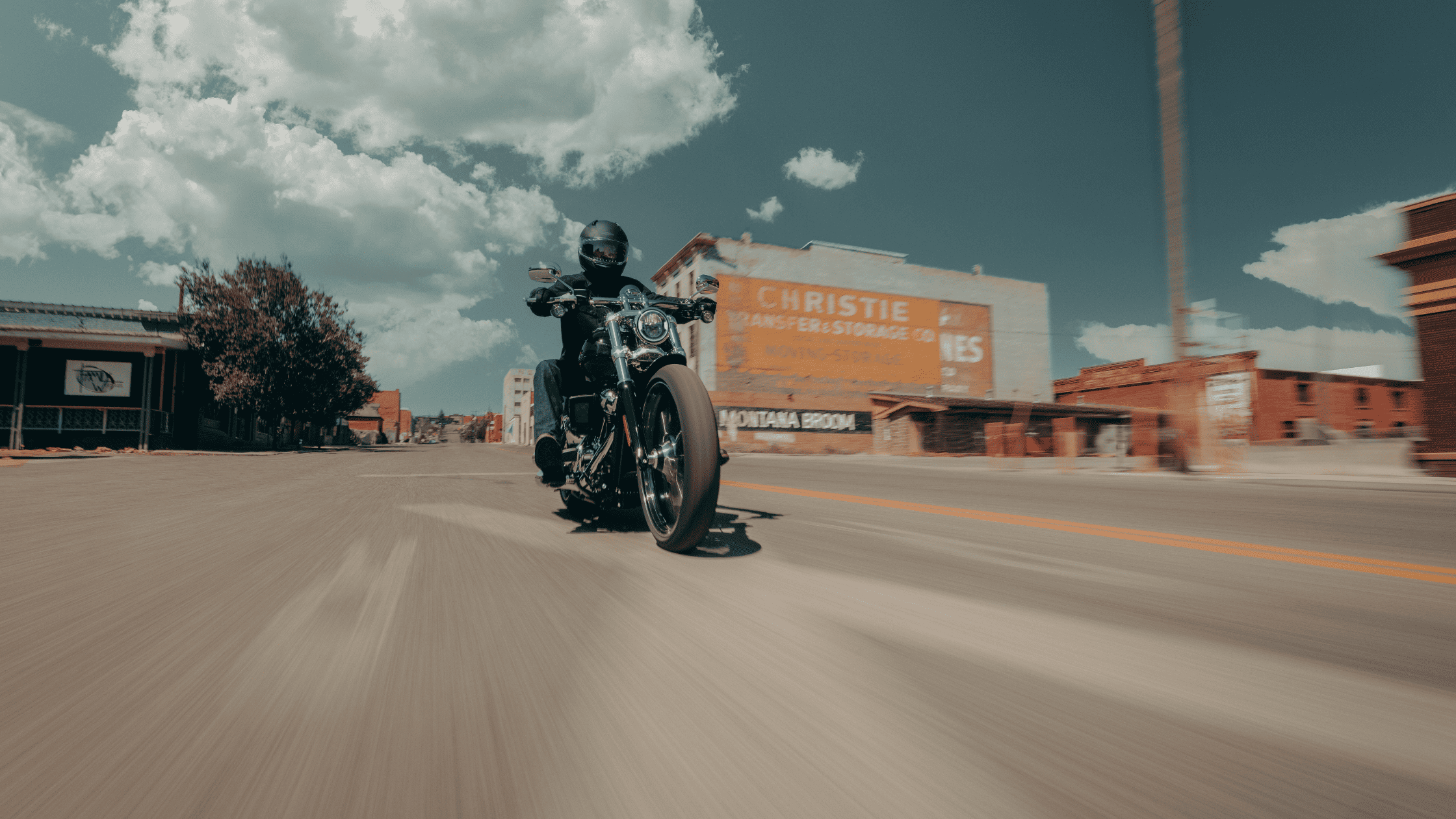 Rider on a 2025 Harley-Davidson Breakout speeding through an empty small-town street.