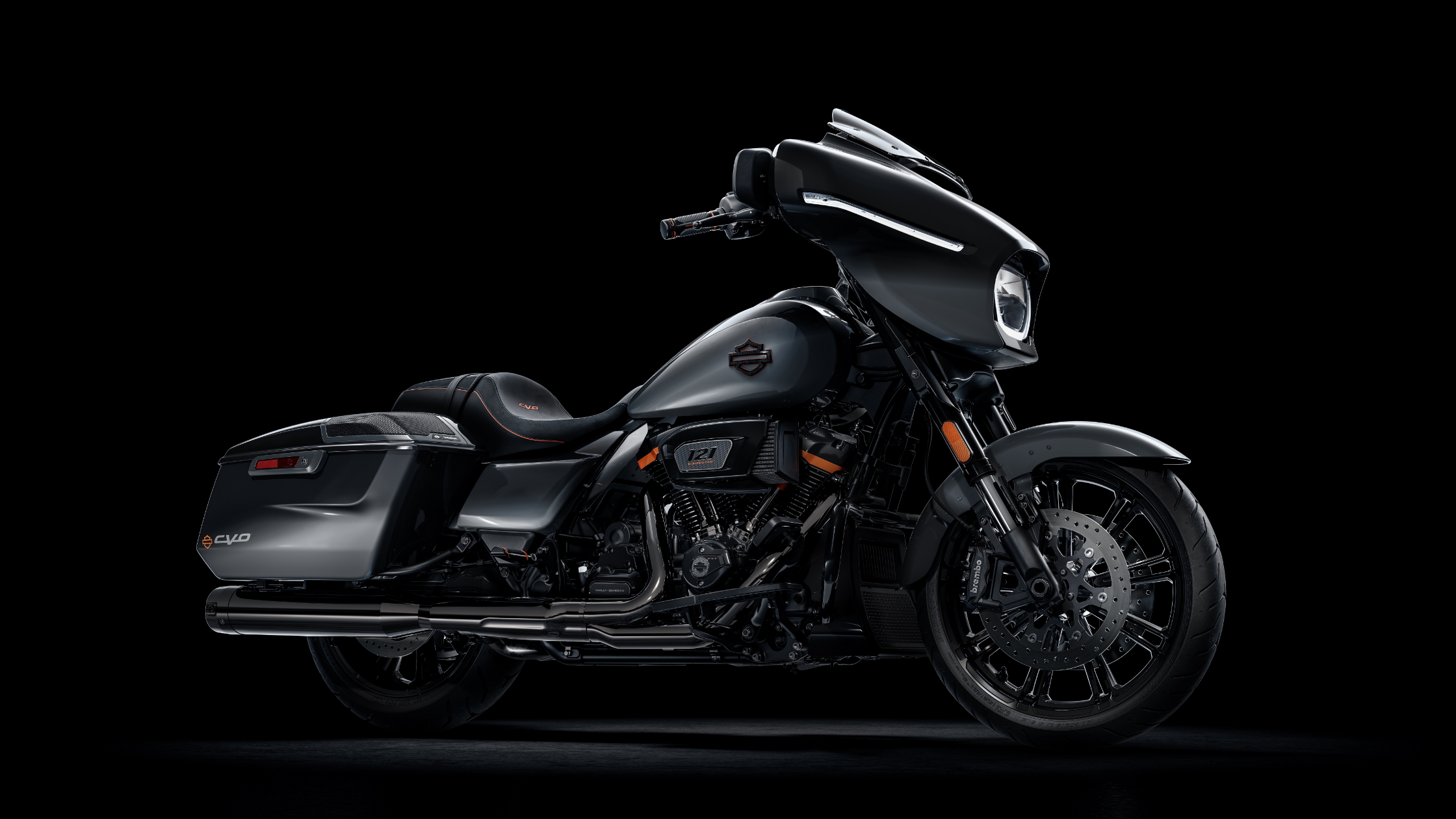 2025 Harley-Davidson CVO Street Glide in dark gray with black and orange accents, angled side view on a dark studio background.