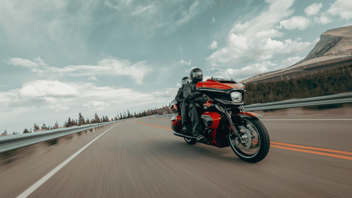 Two-up riding on a red-and-black 2025 Harley-Davidson® Street Glide® Ultra touring through Sanford, FL's mountain roads.