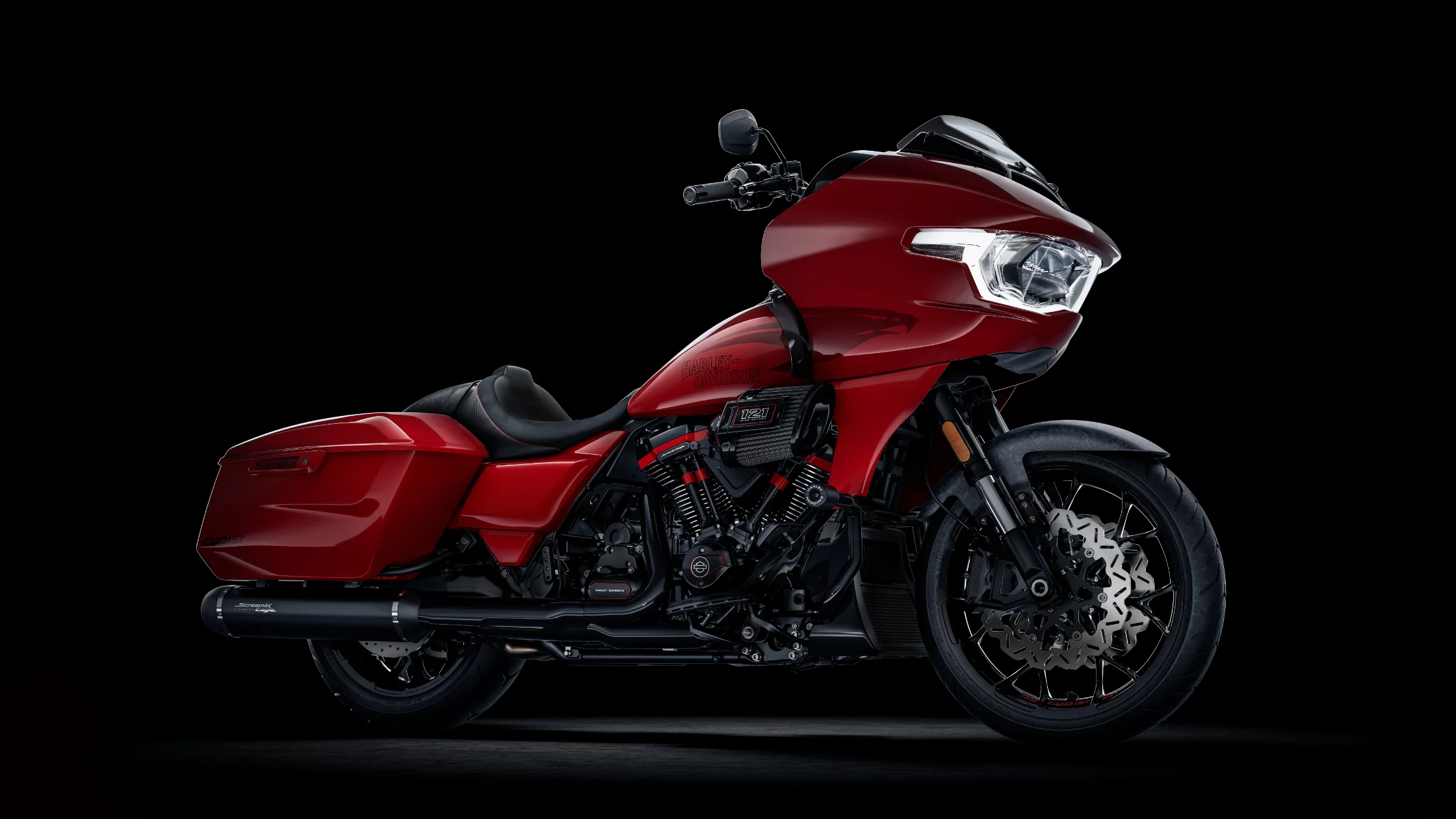 Side profile of 2025 CVO Road Glide ST in bold red finish with blacked-out exhaust and 121 engine.