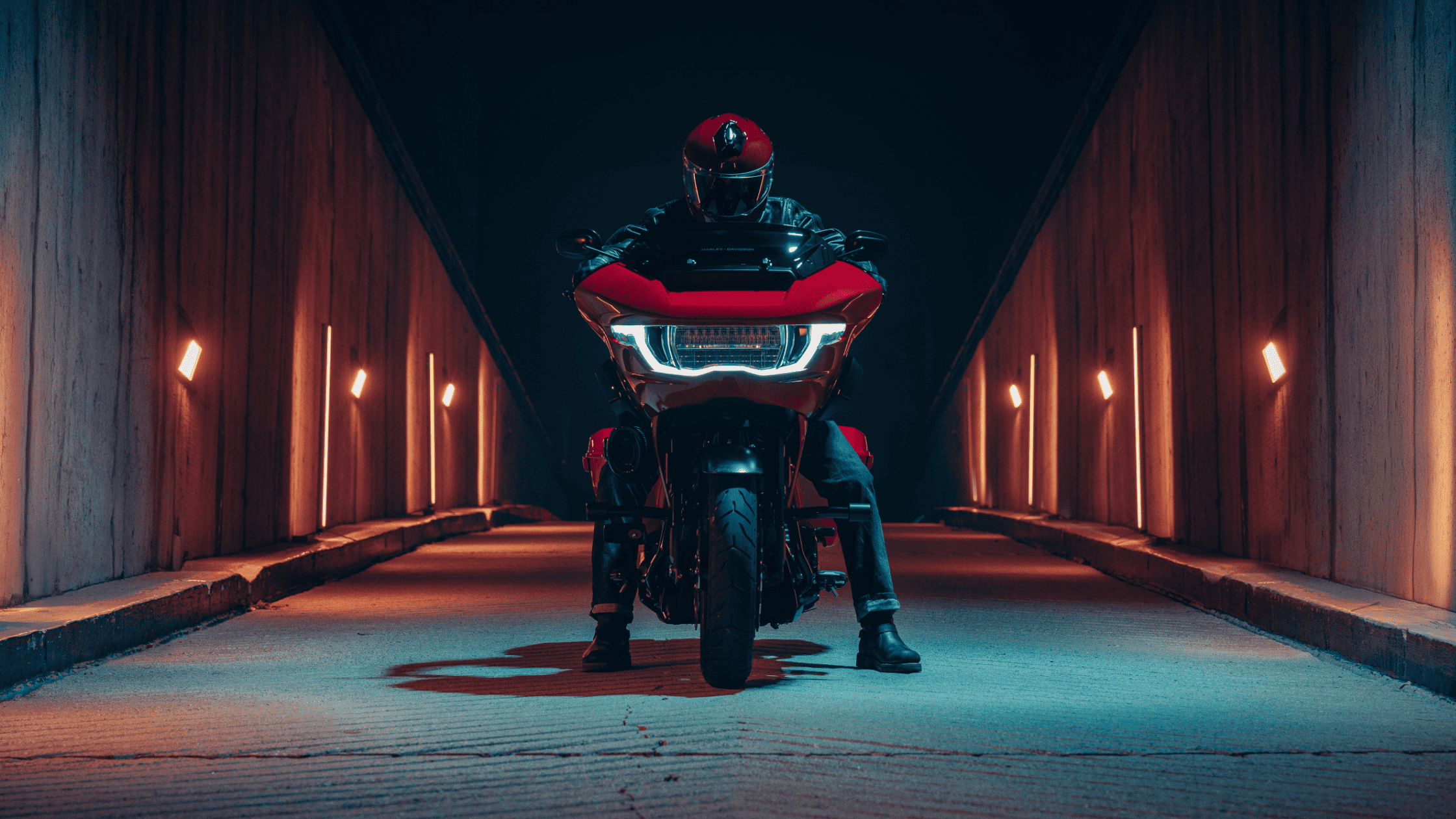 Rider on red CVO Road Glide ST under tunnel lights, night shot front angle