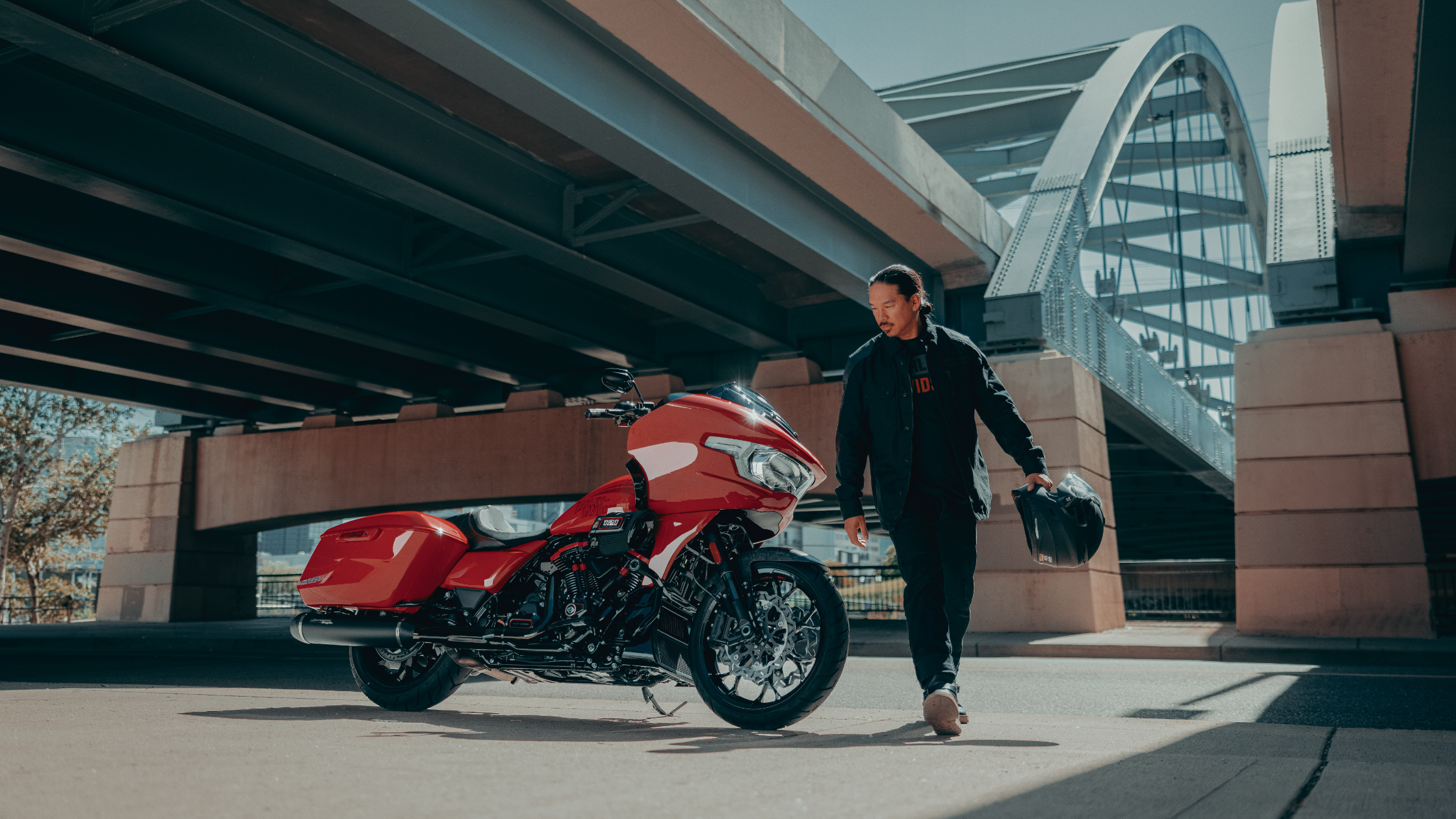 2025 Harley-Davidson® CVO Road Glide ST in red with black accents parked under bridge.
