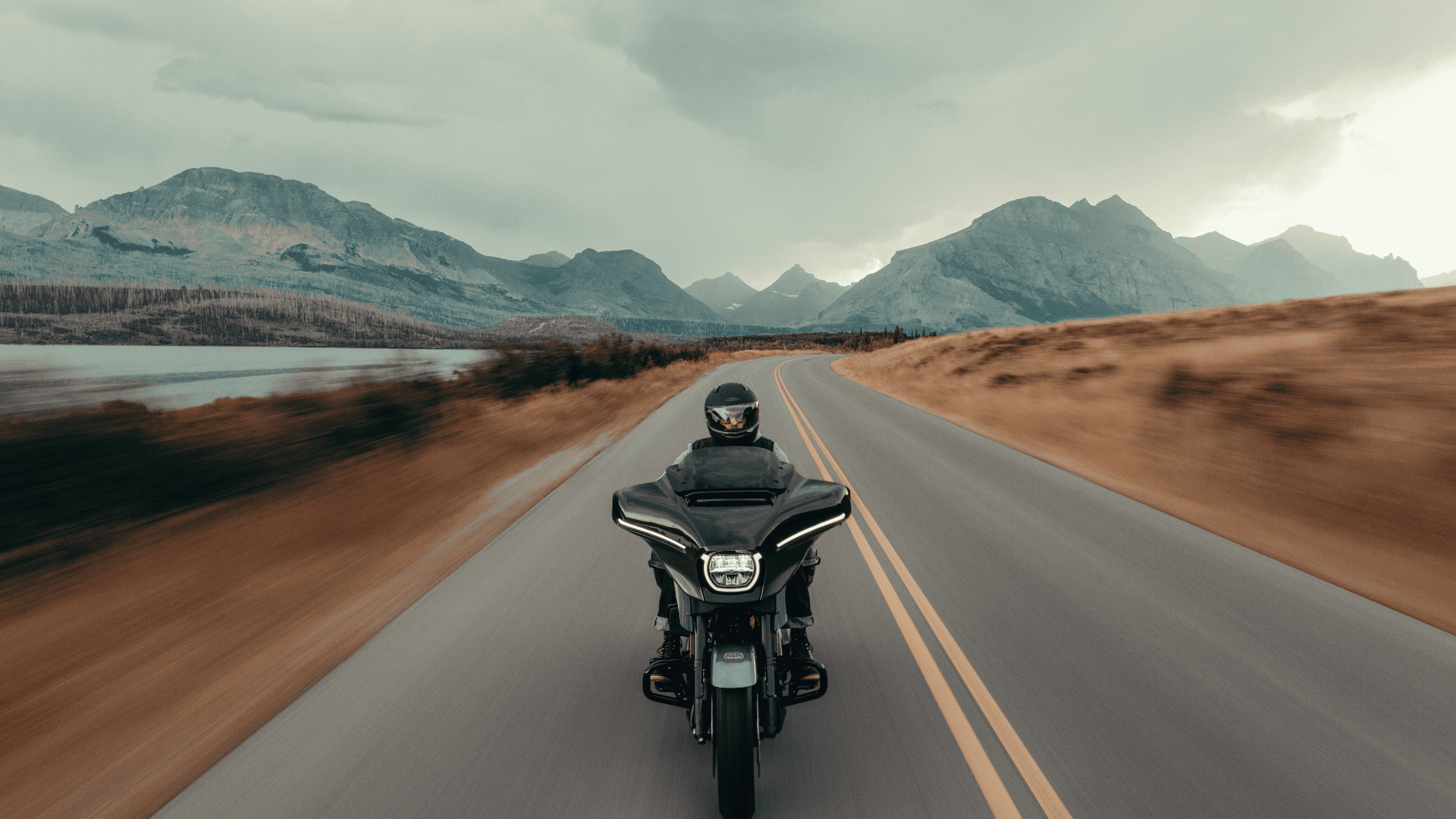 Rider on black 2025 CVO Road Glide ST speeding highway, touring fairing with aggressive stance