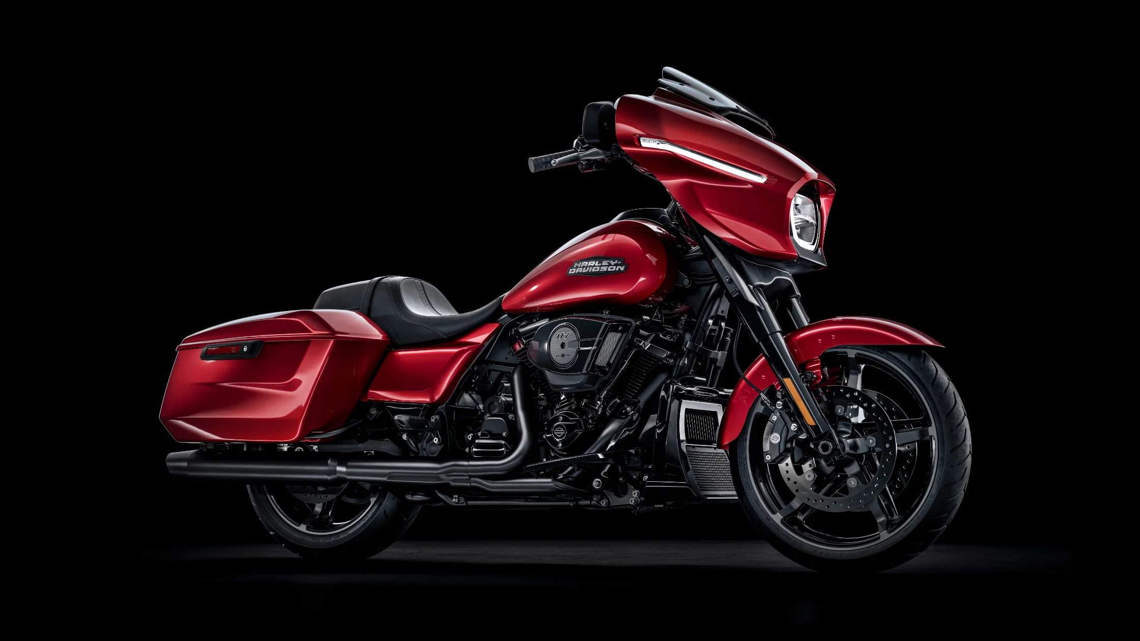 Side profile of 2025 Street Glide B in red finish with saddlebags, LED headlamp, and low-slung stance.