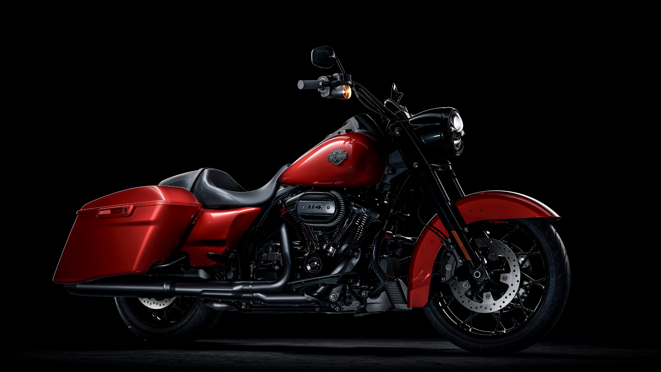 2025 Road King Special motorcycle in red, studio shot with black background and chrome details.