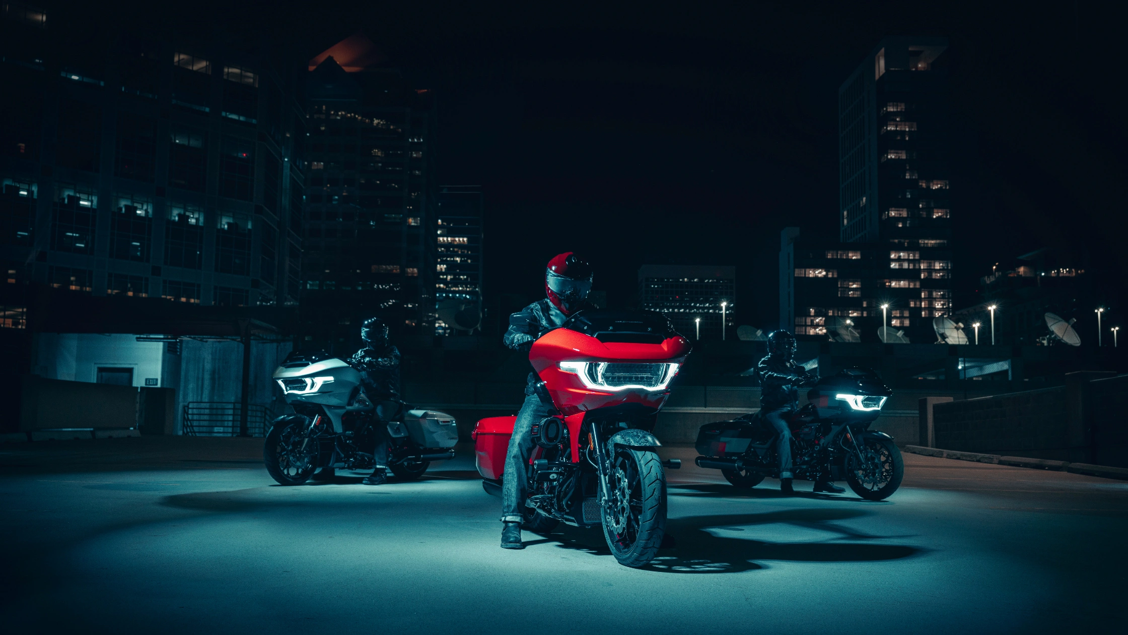 2025 Harley-Davidson CVO Road Glide ST in bright red with LED lights, parked at night in the city.