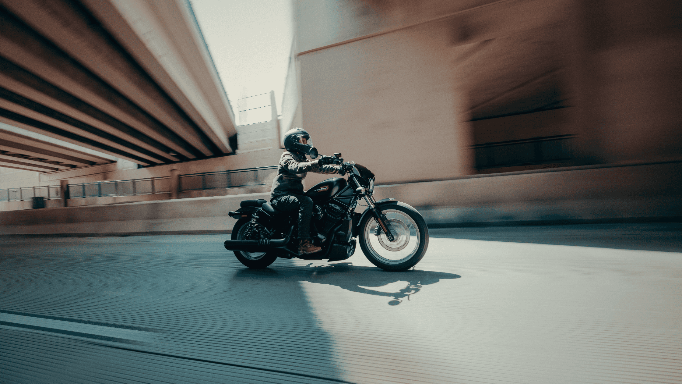 2025 Nightster S motorcycle with rider illuminated at night with headlight shining forward