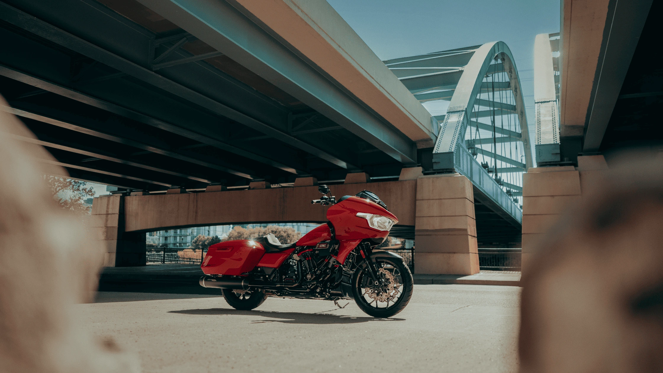 2025 Harley-Davidson® CVO™ Road Glide® in custom red paint, positioned under a bridge in McDonough, GA, emphasizing its premium performance and design.