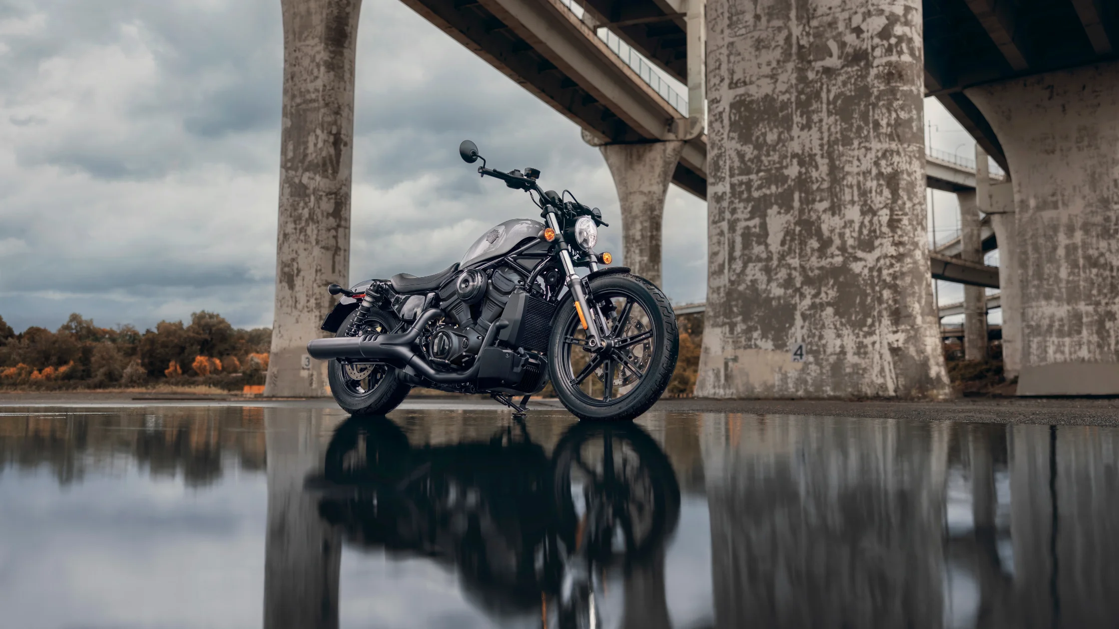 2025 H-D® Nightster® in silver parked under concrete bridge with reflection on wet surface