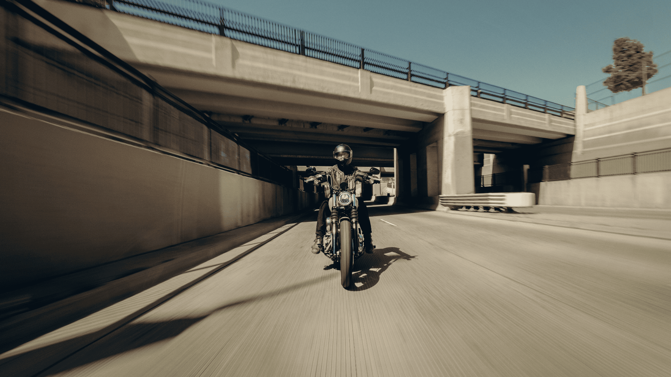 Rider on 2025 Harley-Davidson Street Bob cruising confidently through shaded city tunnel.