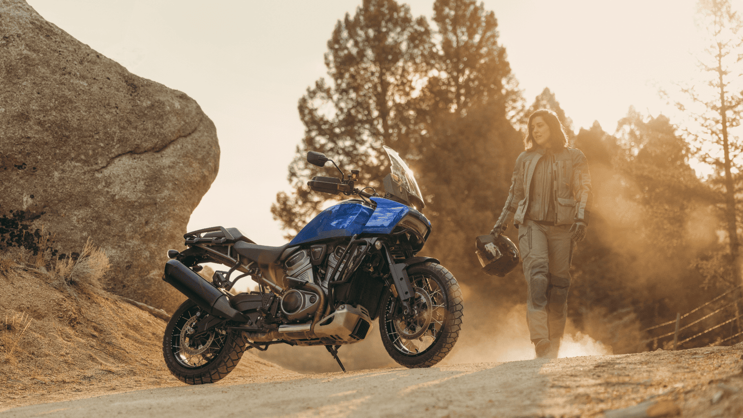 2025 Harley-Davidson® Pan America® 1250 Special parked on rugged terrain with a rider beside it, highlighting its off-road capability near Sanford, FL.