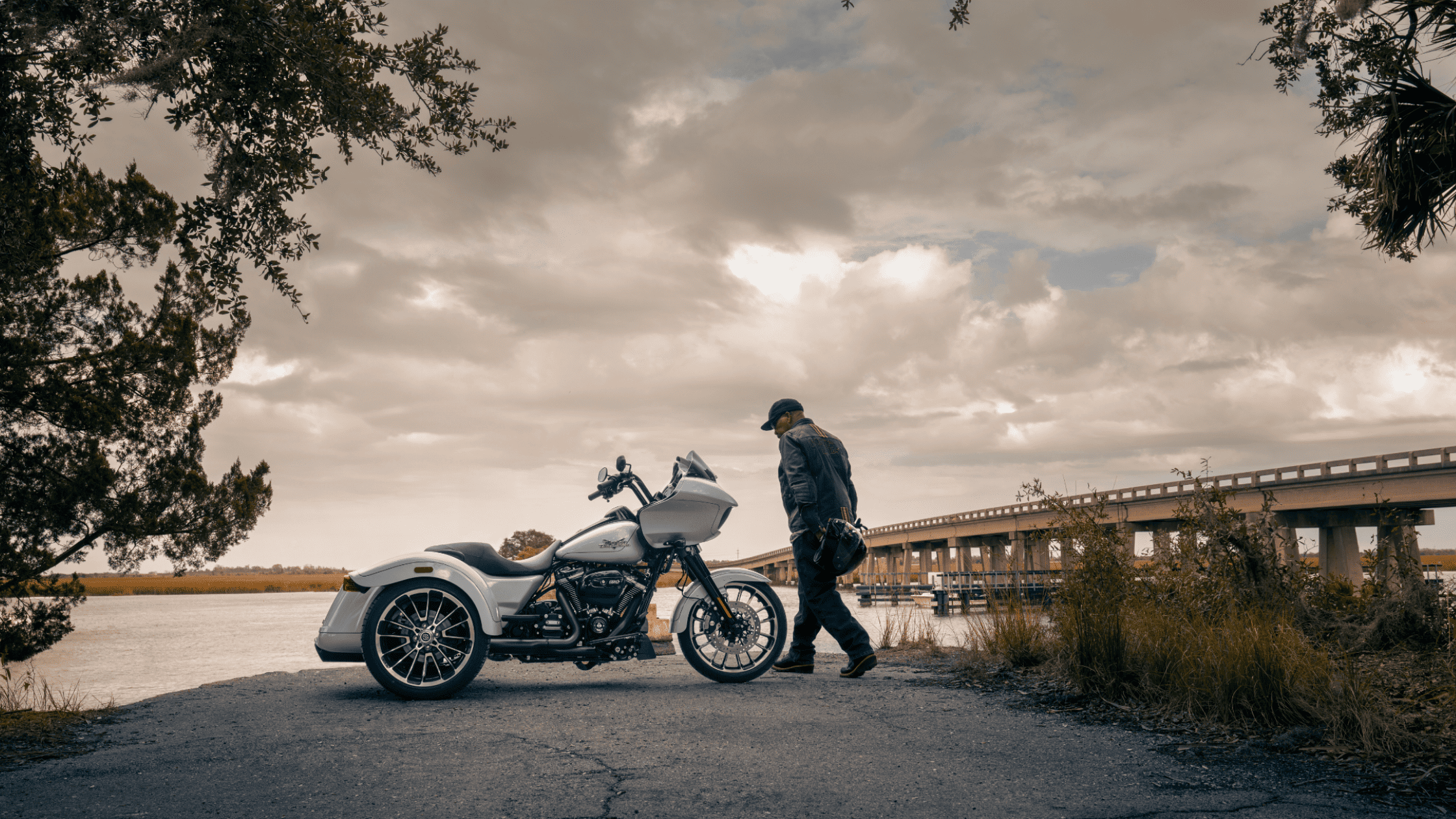 2025 Harley-Davidson Road Glide 3 trike beside bridge with rider preparing for scenic ride