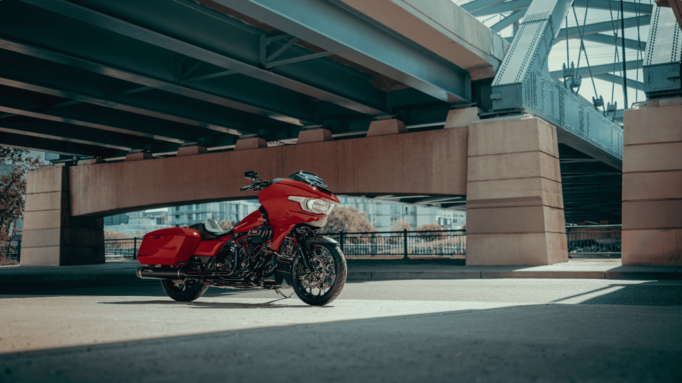 Red 2025 Harley-Davidson CVO Road Glide ST parked under an urban bridge showcasing performance styling.