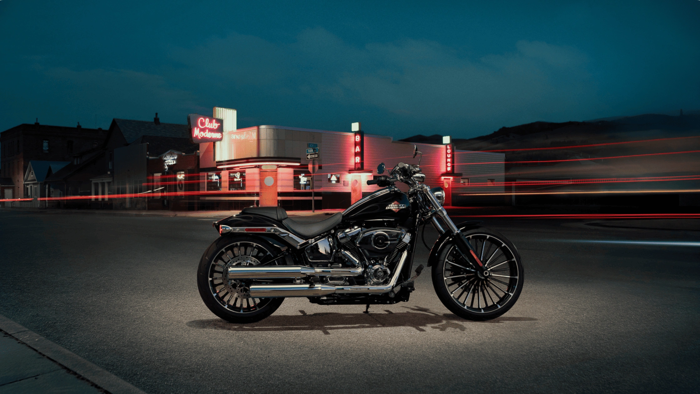 2025 Harley-Davidson Breakout near McDonough, GA parked at night with neon lights in the background, showing its sleek chrome and custom style.
