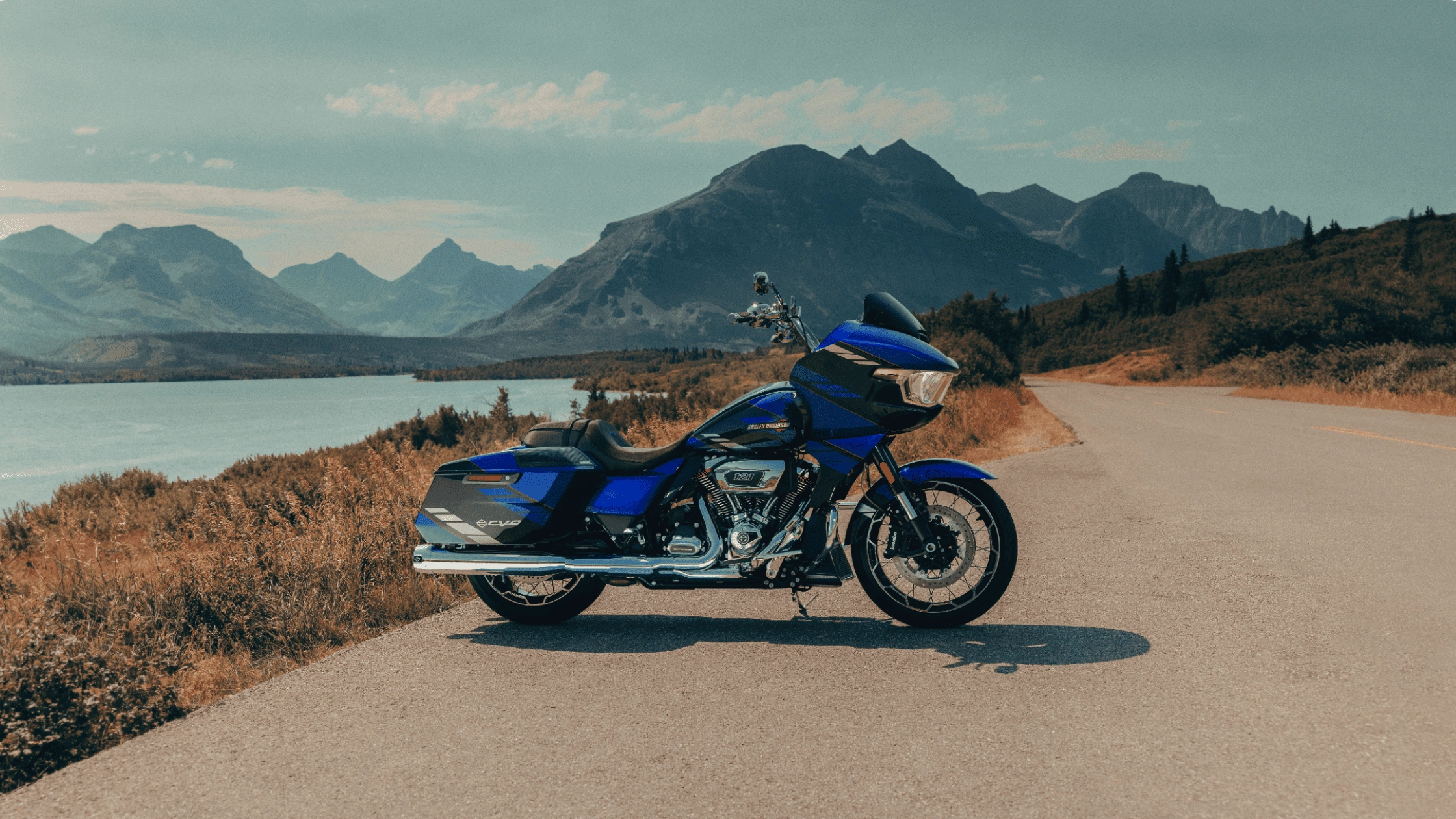 2025 Harley-Davidson CVO Road Glide near Sunrise, FL parked along a scenic waterfront road with mountain views, highlighting premium touring style.