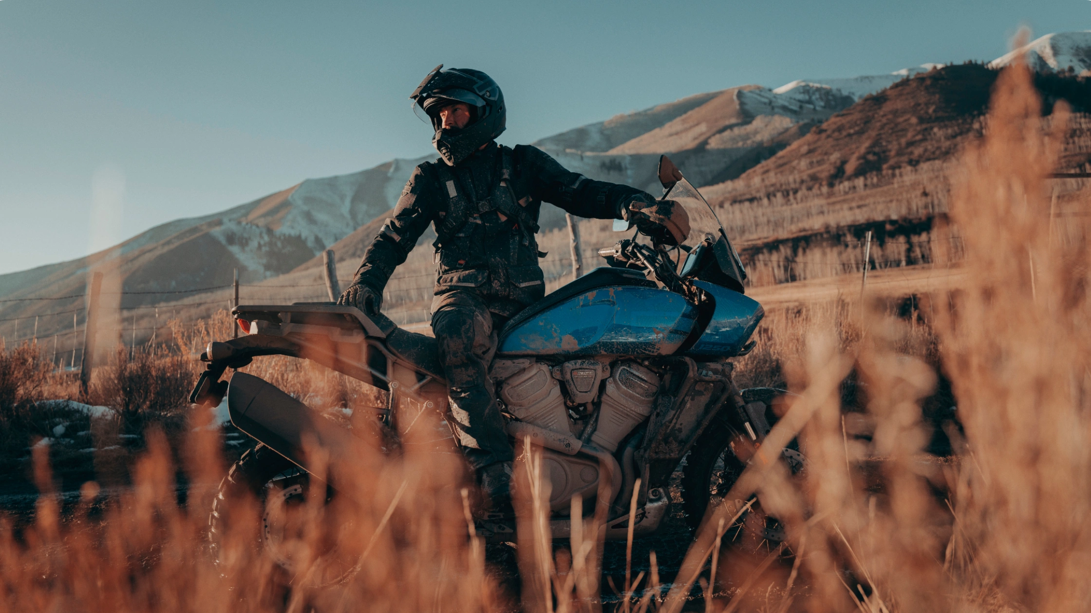 2025 Harley-Davidson Pan America 1250 Special rider off-road with adventure gear in dry landscape.