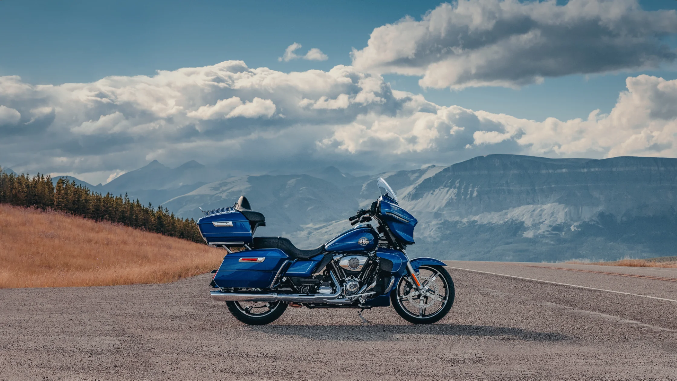2025 Harley-Davidson Street Glide Ultra touring bike on open highway with mountain scenery.