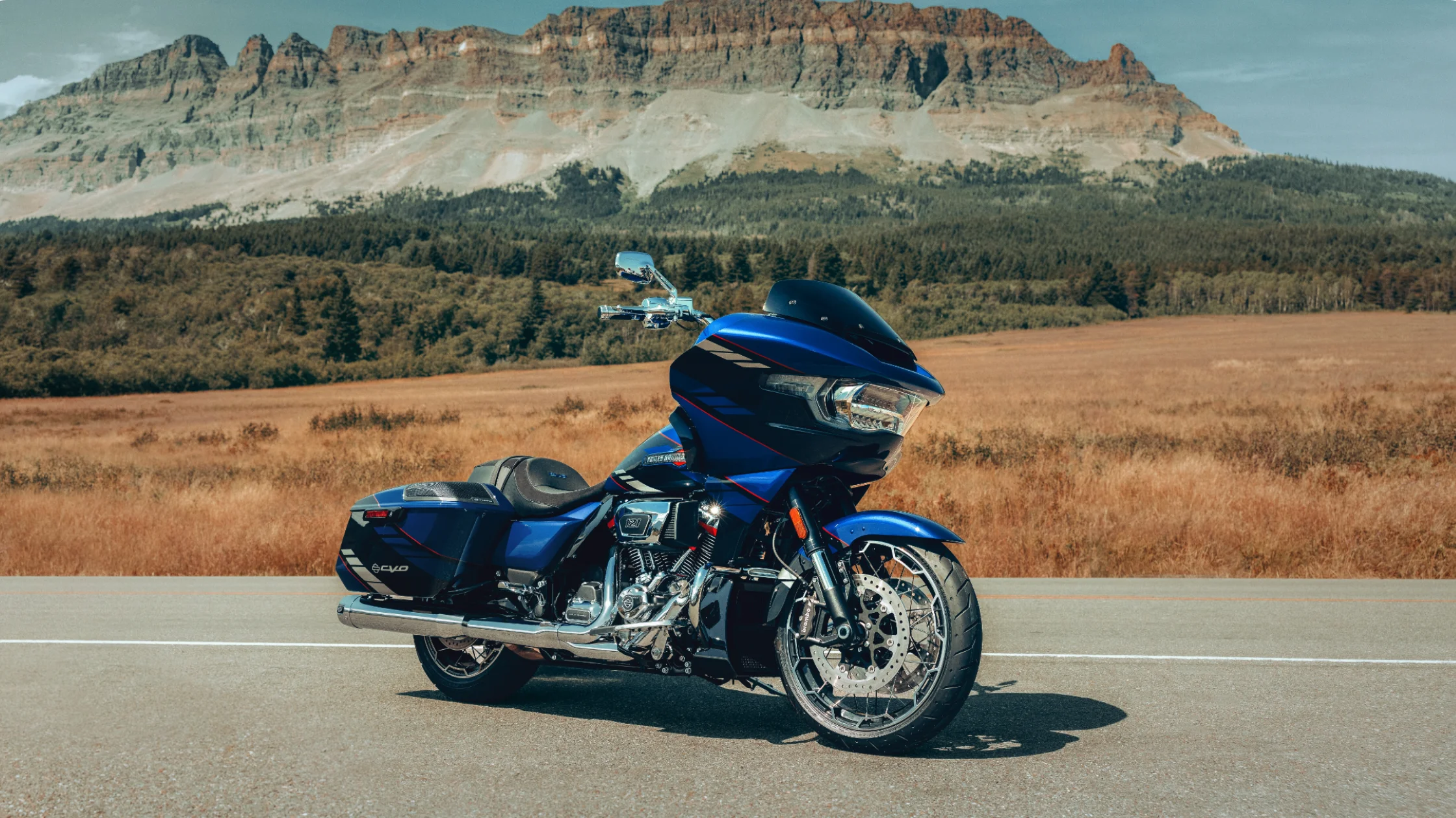 2025 Harley-Davidson CVO Road Glide parked on scenic highway with mountain backdrop.
