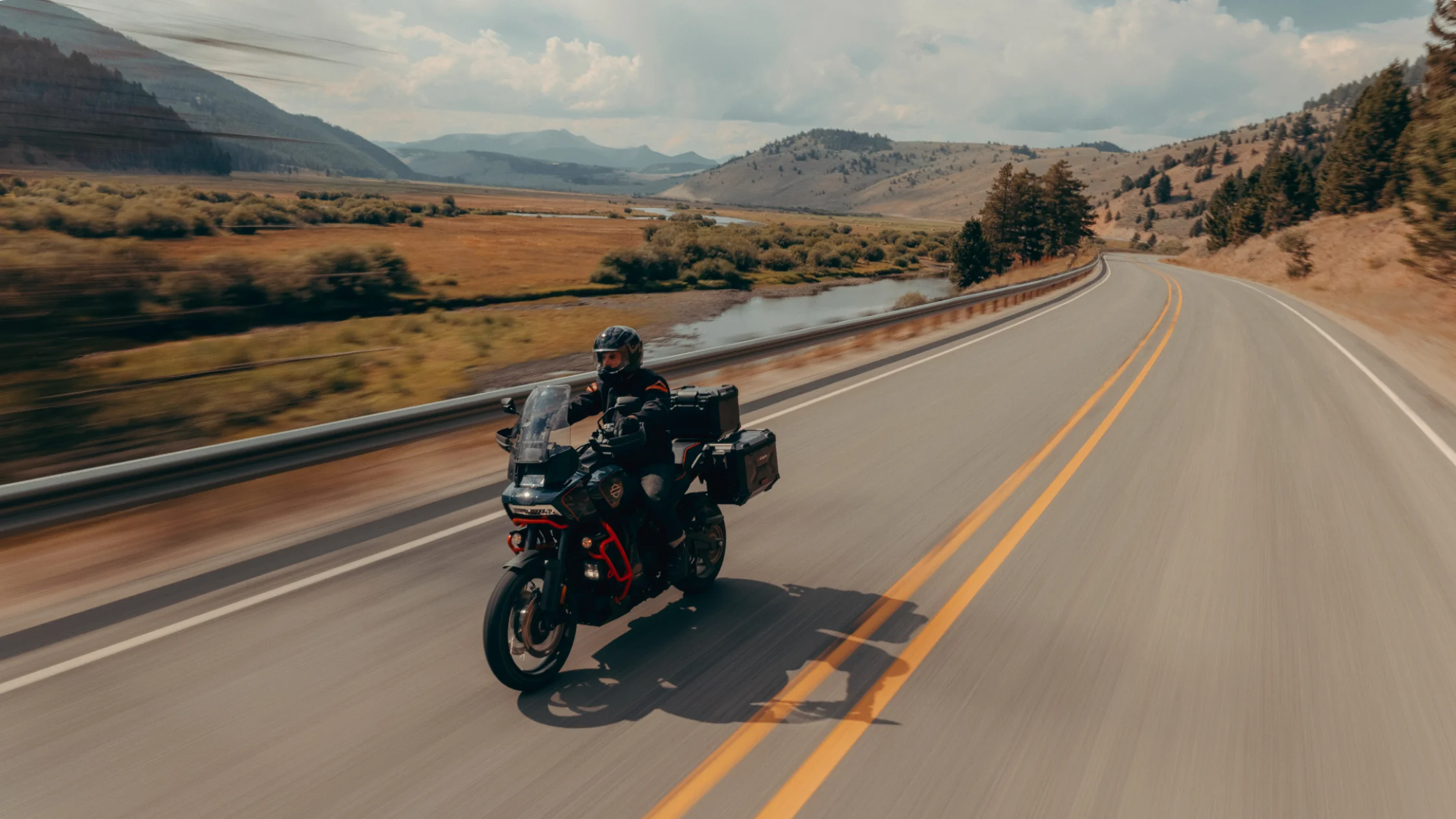 2025 Harley-Davidson® CVO™ Pan America® riding on a scenic mountain road with luggage attached