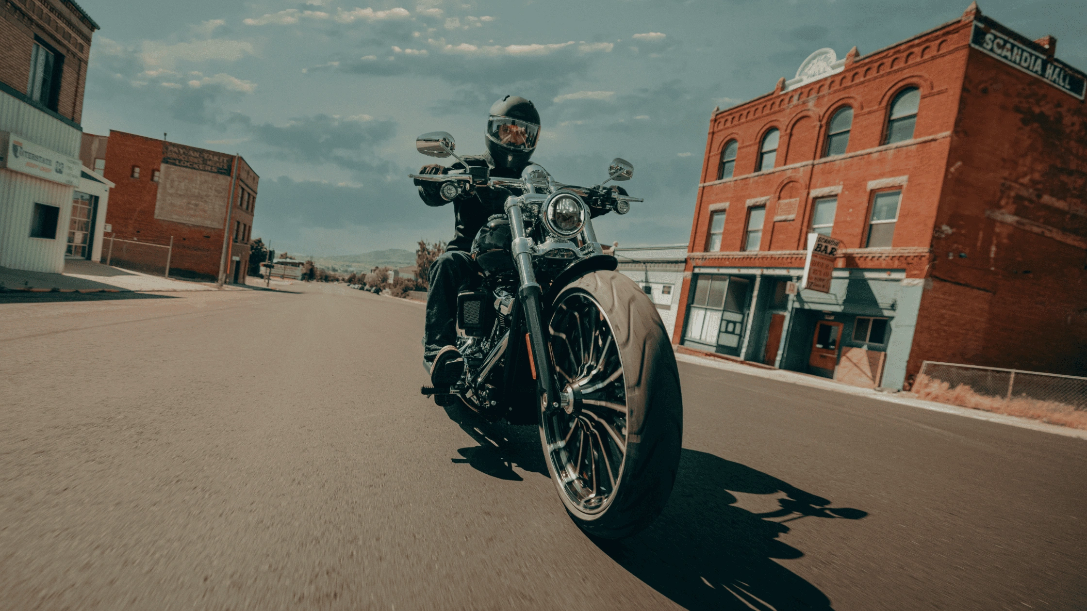 2025 Harley-Davidson Breakout riding through a small town street, highlighting its power and custom cruiser style for McDonough riders.