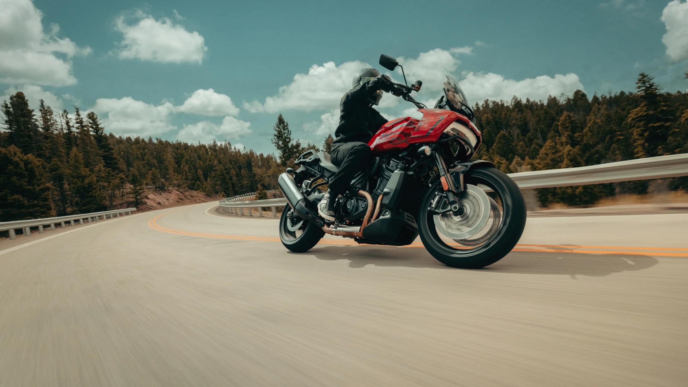 2025 Harley-Davidson® Pan America® 1250 ST leaning through mountain curve on a sunny day