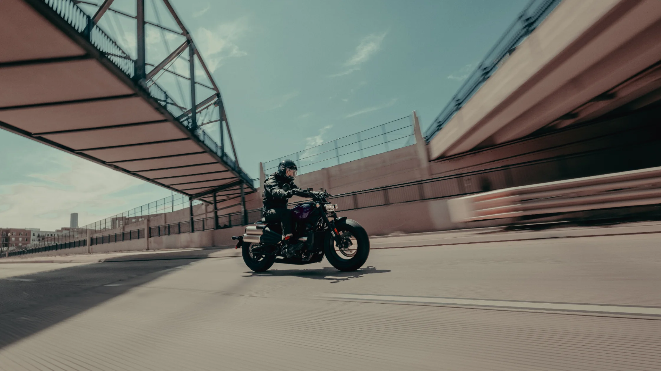 2025 Harley-Davidson® Sportster® S riding through city streets under steel bridge structure