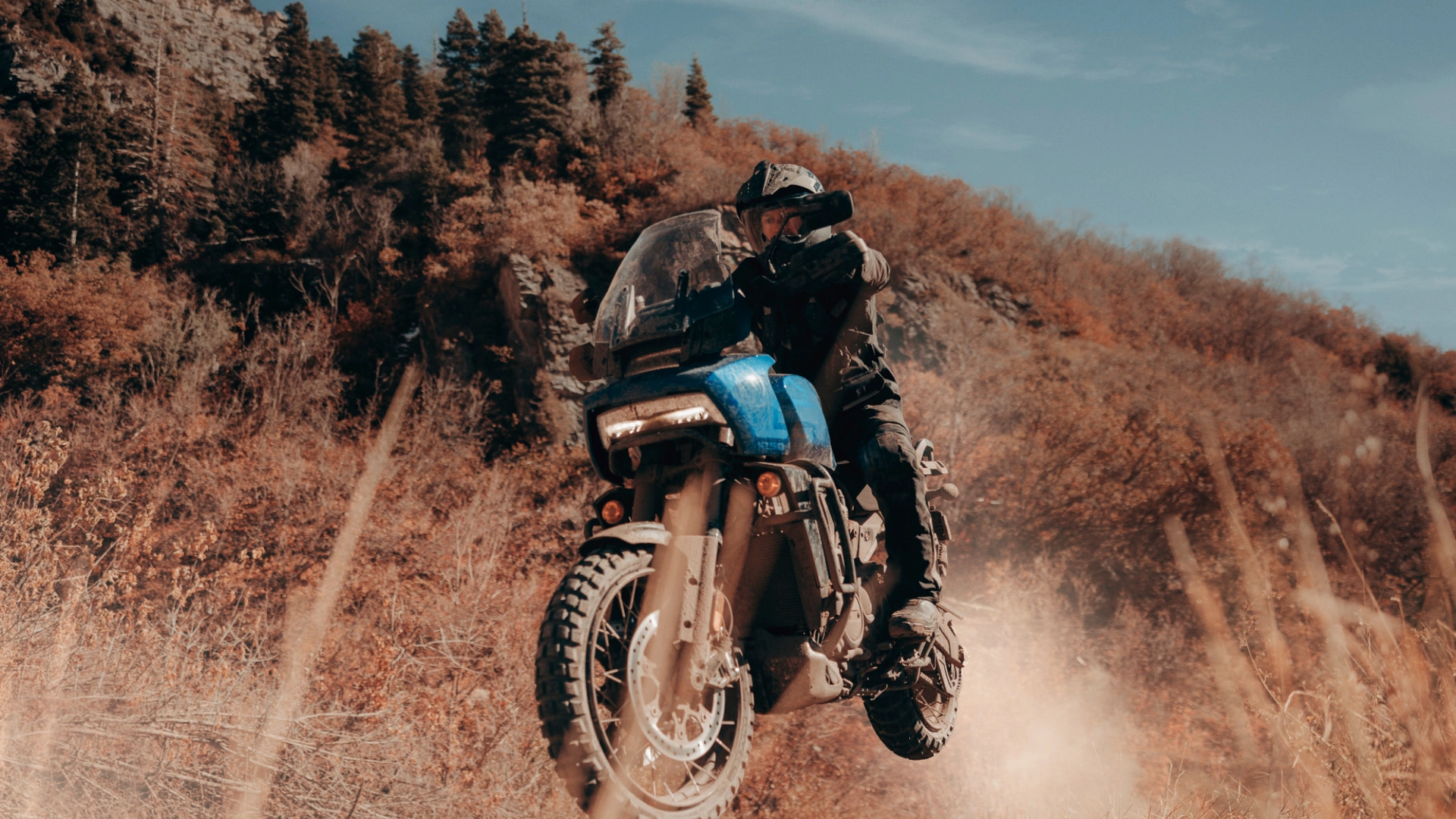 2025 Harley-Davidson® Pan America® 1250 Special leaning into a mountain curve on a scenic autumn road, emphasizing agility and touring capability.