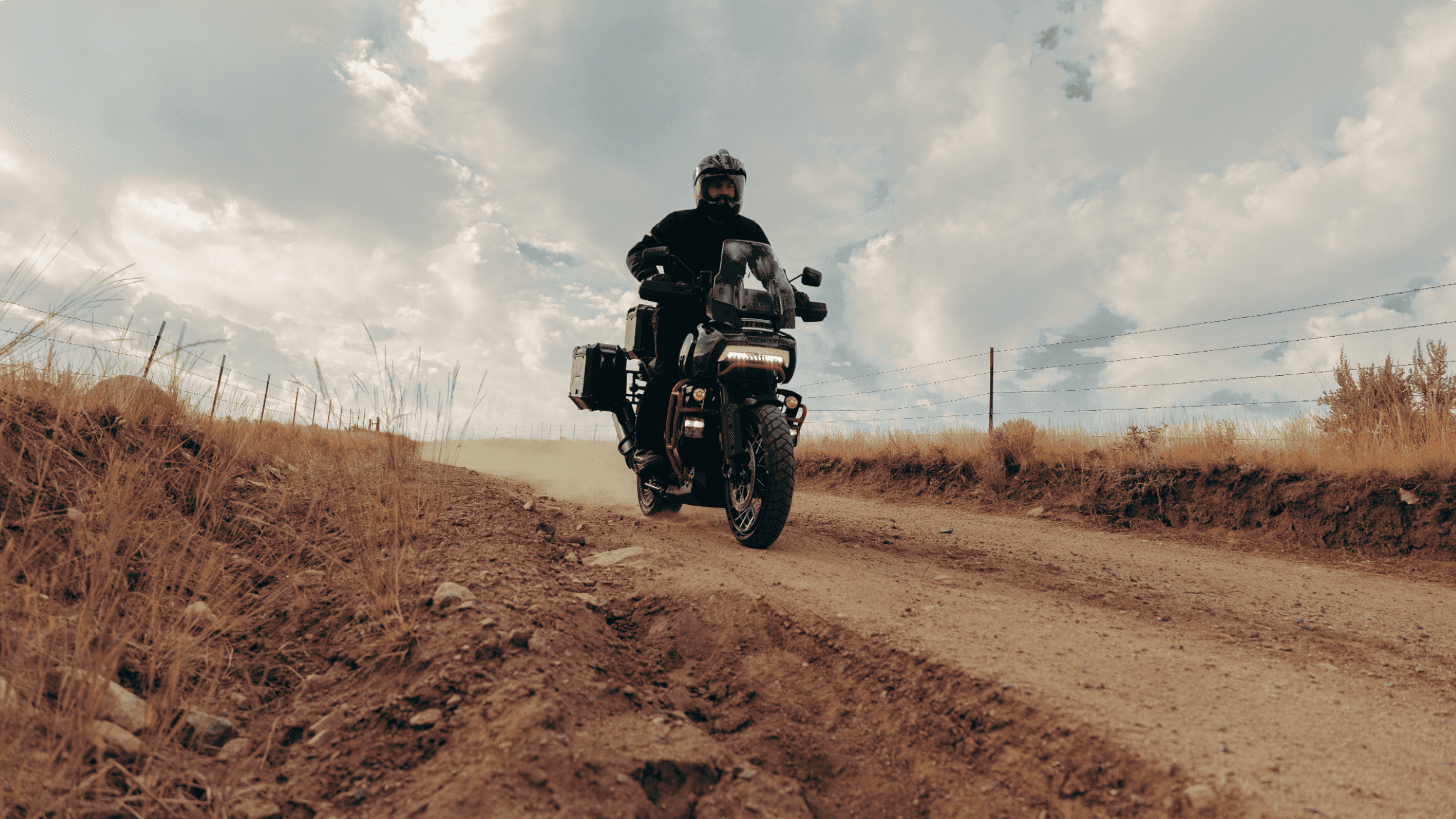 2025 Harley-Davidson CVO Pan America riding on a dusty off-road trail with adventure gear mounted