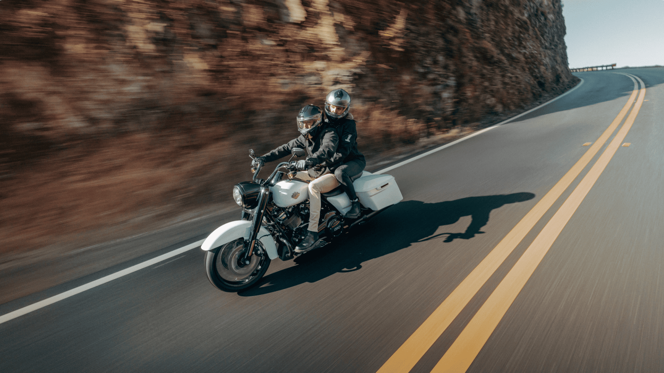 2025 Harley-Davidson Road King Special with rider and passenger leaning through mountain highway turn