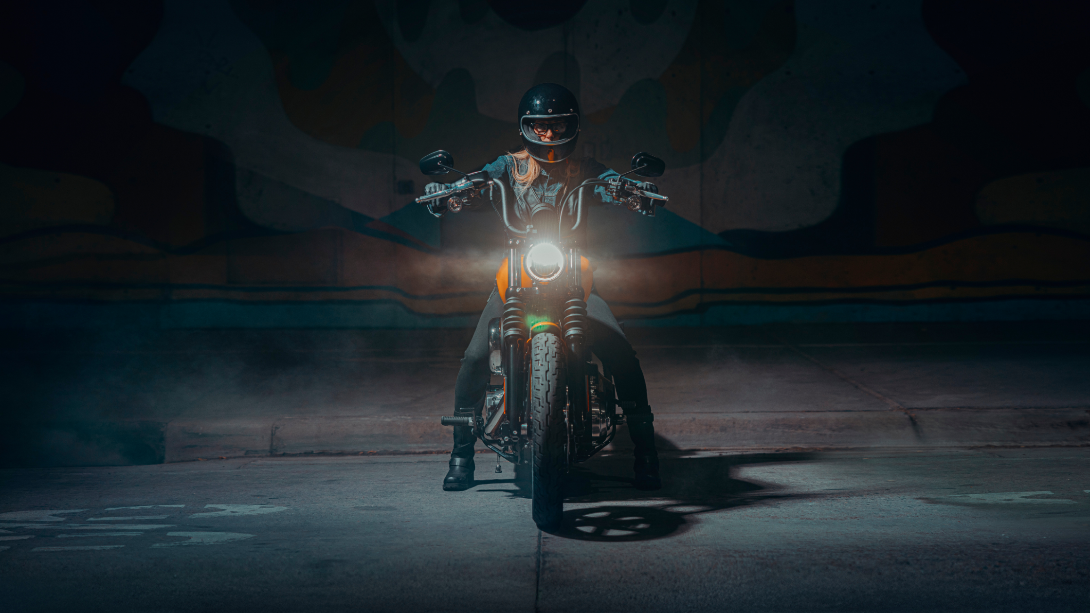 2025 Harley-Davidson Street Bob with rider approaching head-on in a dimly lit urban tunnel with headlight glowing.