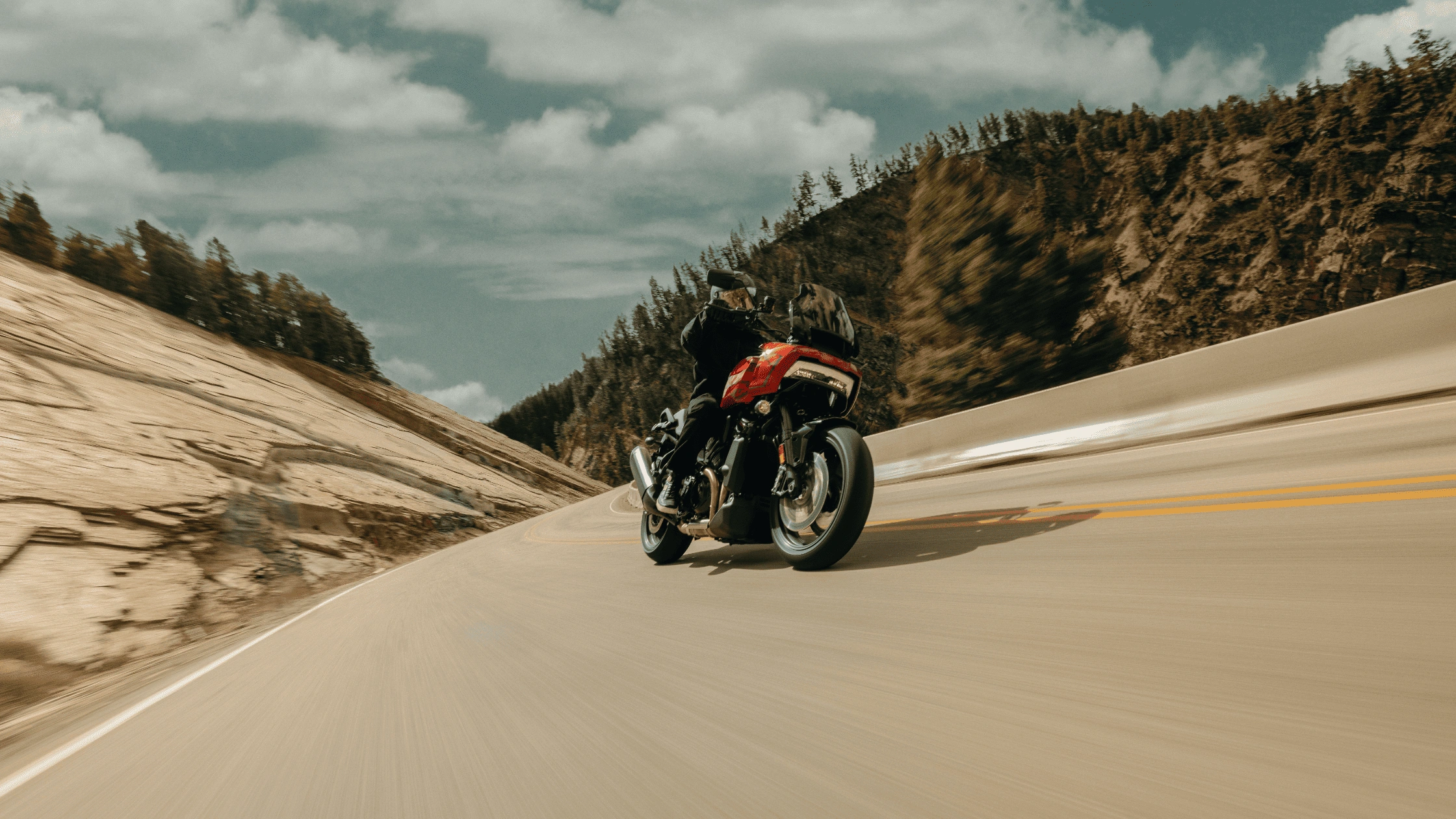 2025 Harley-Davidson Pan America 1250 ST leaning through a mountain curve, showcasing adaptive ride height for McDonough daily commuters.