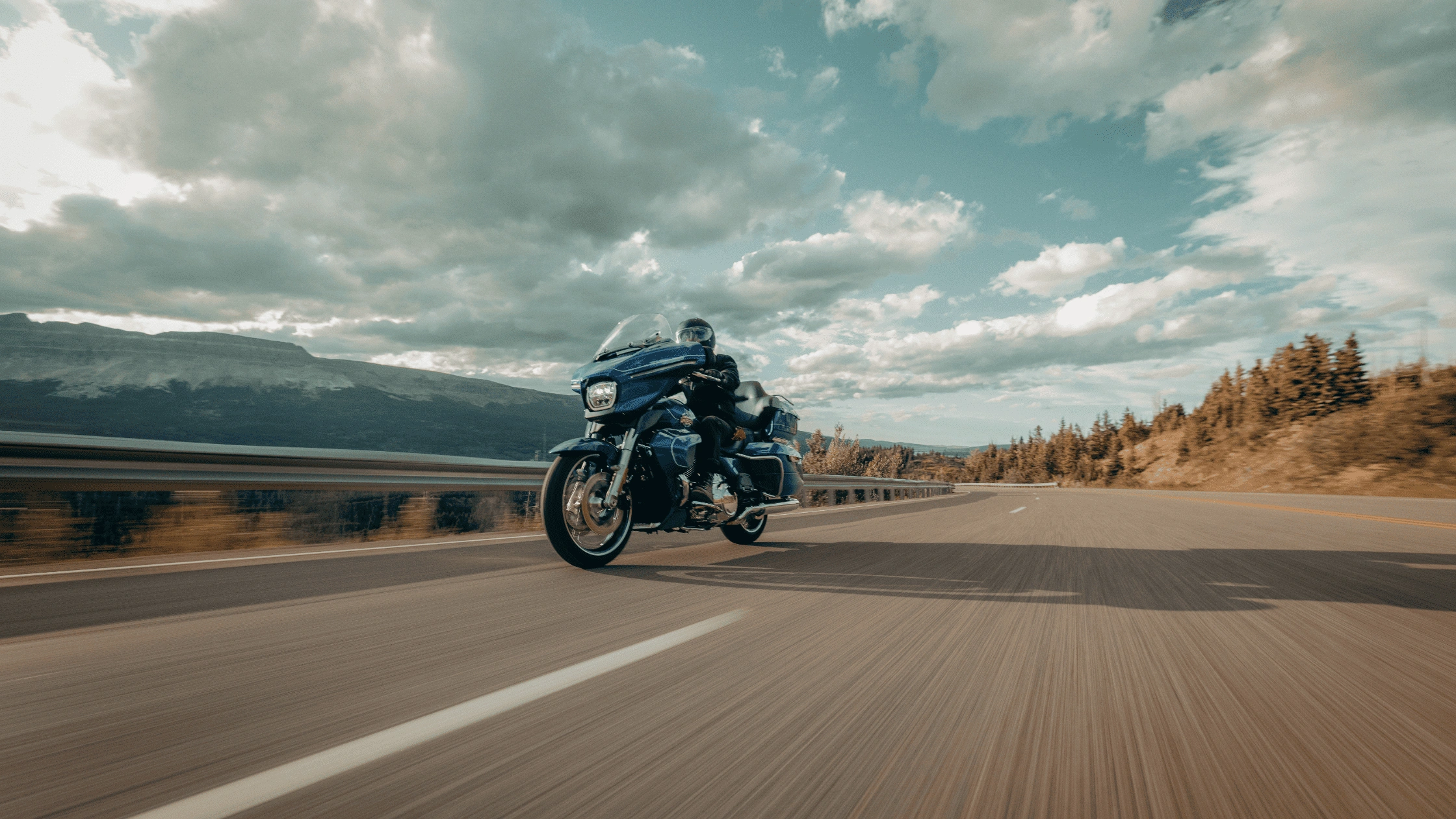 2025 Harley-Davidson® Street Glide® Ultra riding along an open highway near Baton Rouge, LA, showcasing its touring fairing, passenger comfort features, and long-distance road presence.