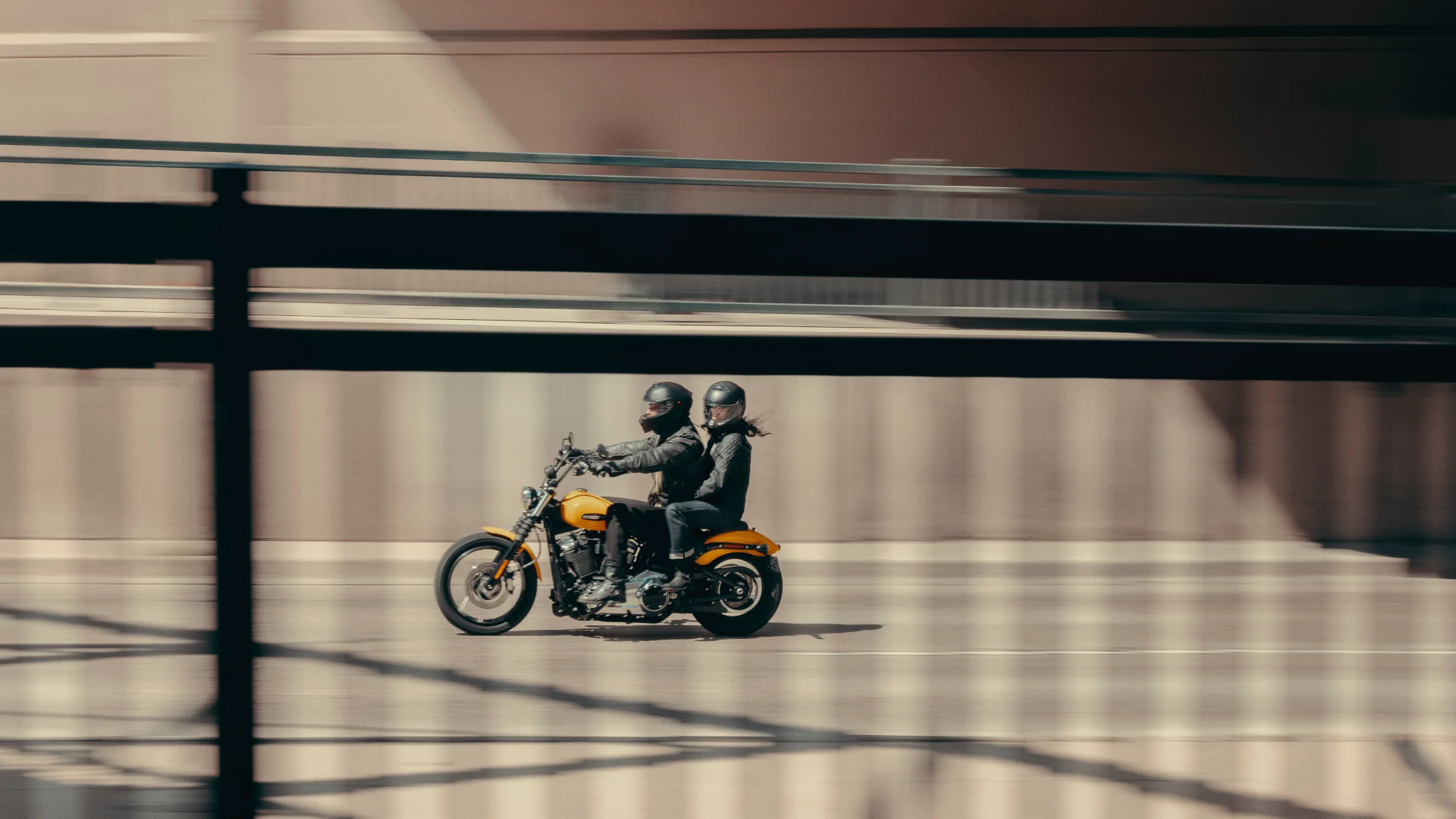 2025 Harley-Davidson® Street Bob® two-up riding shot with yellow tank and minimalist bobber style