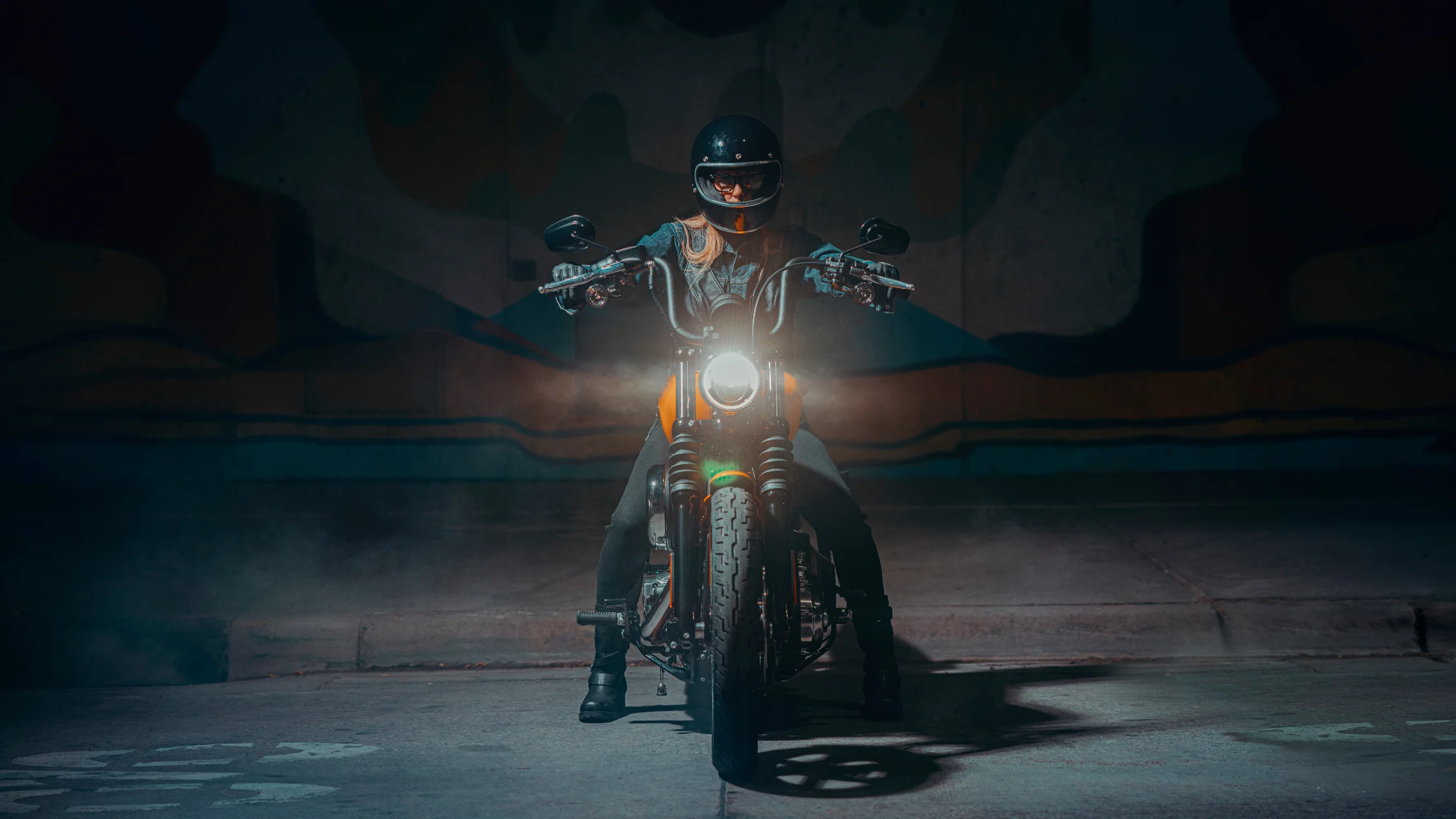 2025 Harley-Davidson® Street Bob® front view at night with headlight on and smoke