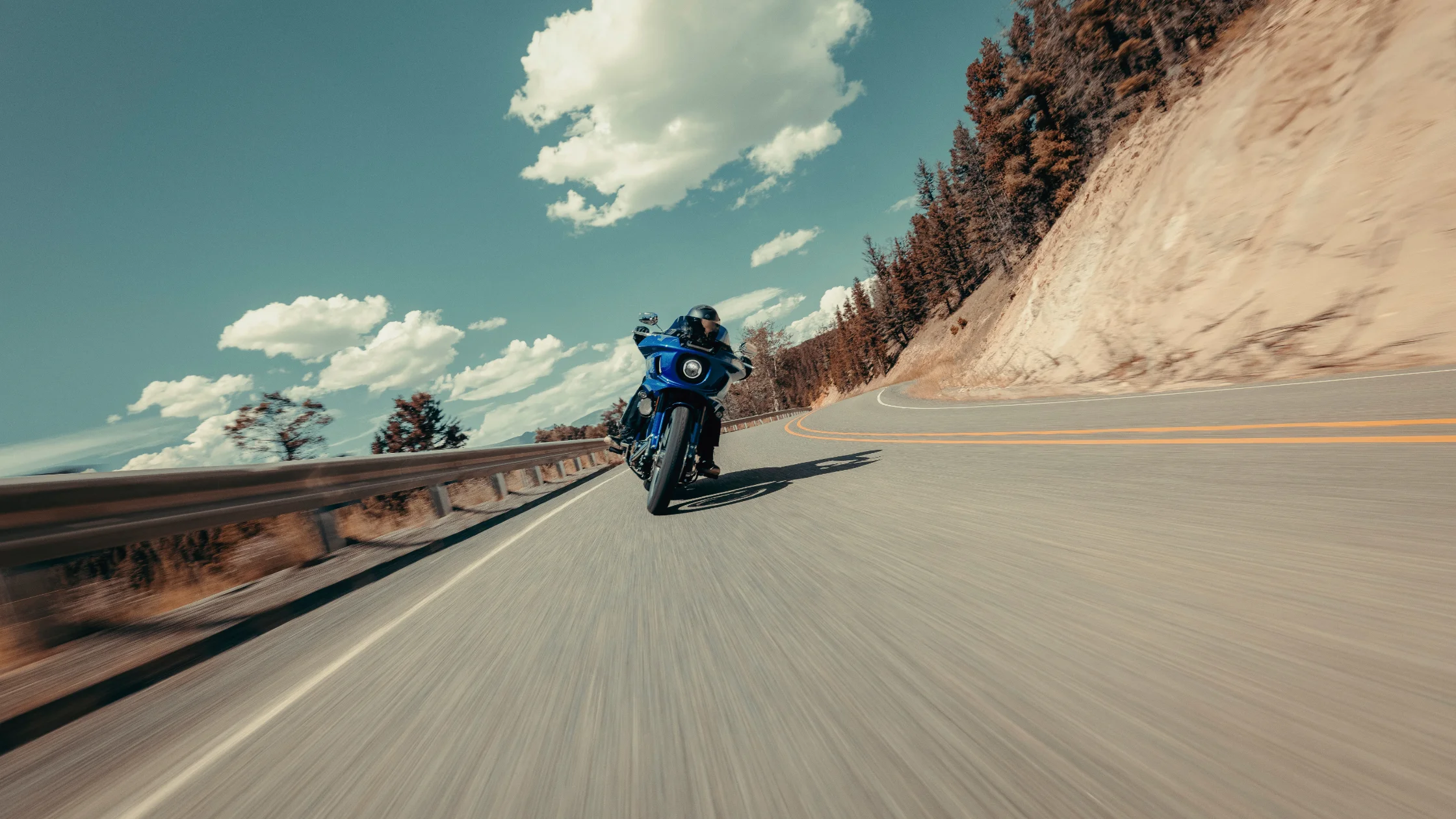 2025 Harley-Davidson® Low Rider® ST carving canyon road with frame-mounted fairing.
