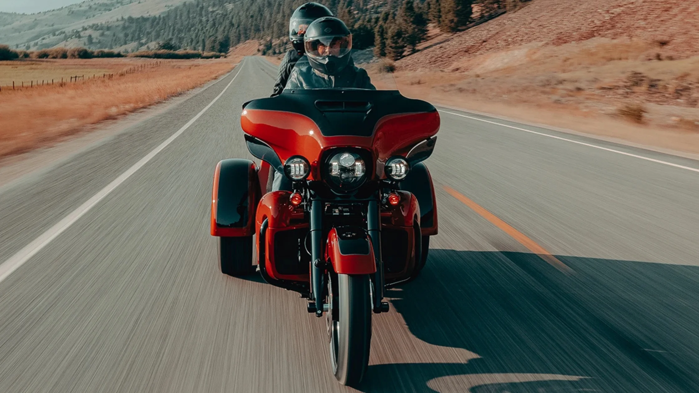 2025 Harley-Davidson® Tri Glide® Ultra front view riding scenic rural roadway.