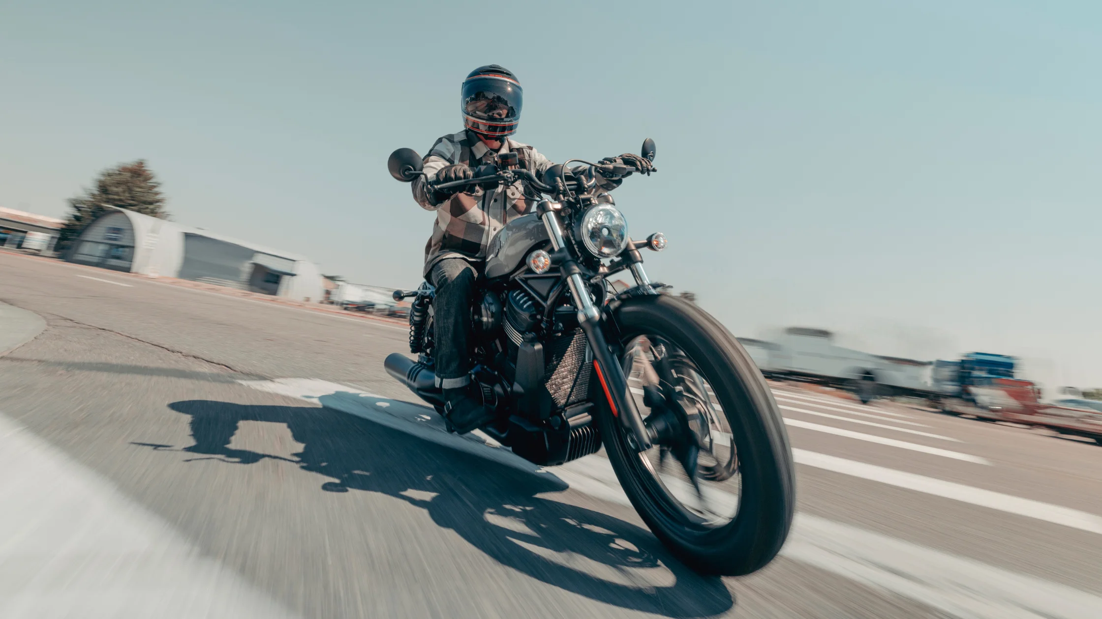 Rider cornering on a 2026 Harley-Davidson® Nightster® motorcycle during an urban road ride.