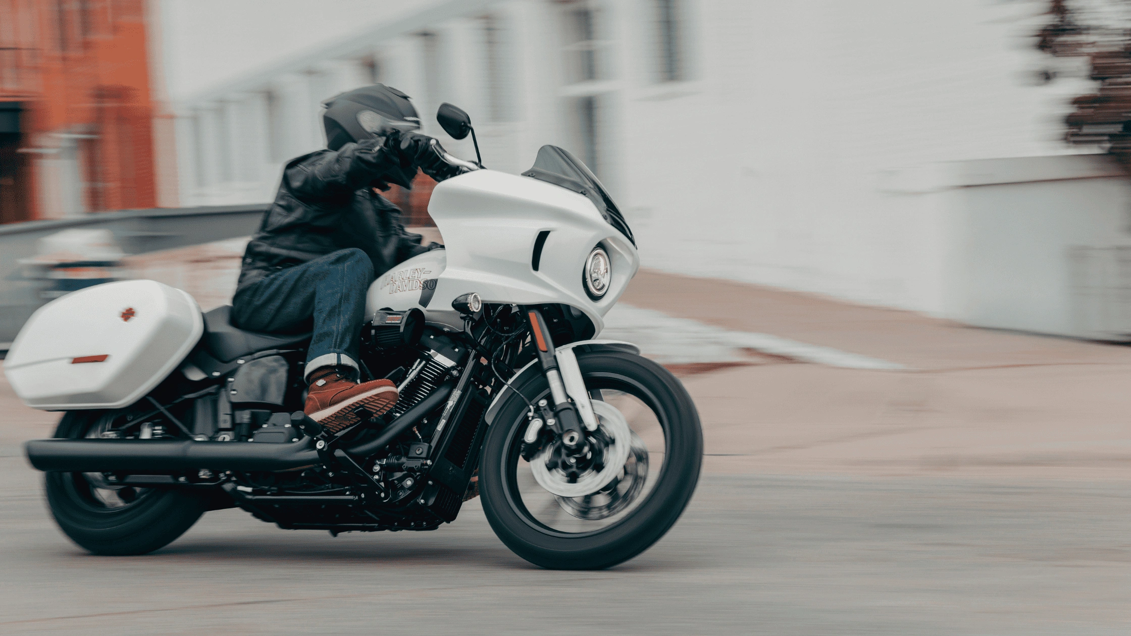 Rider leaning into a turn on a white 2026 Harley-Davidson Low Rider ST touring motorcycle in Baton Rouge, Louisiana.