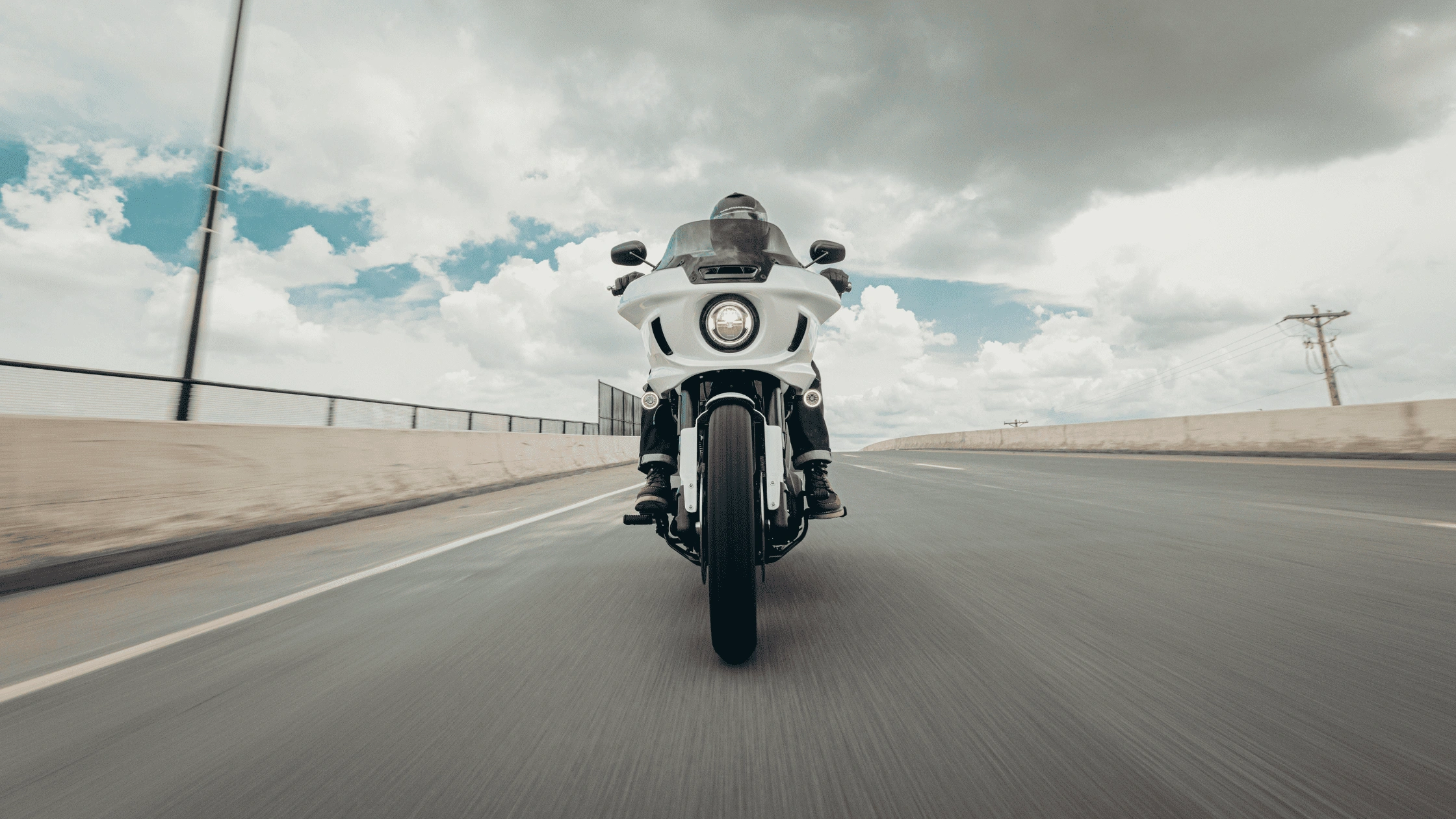 Front view of a white 2026 Harley-Davidson Low Rider ST riding on an open highway near Baton Rouge, Louisiana.