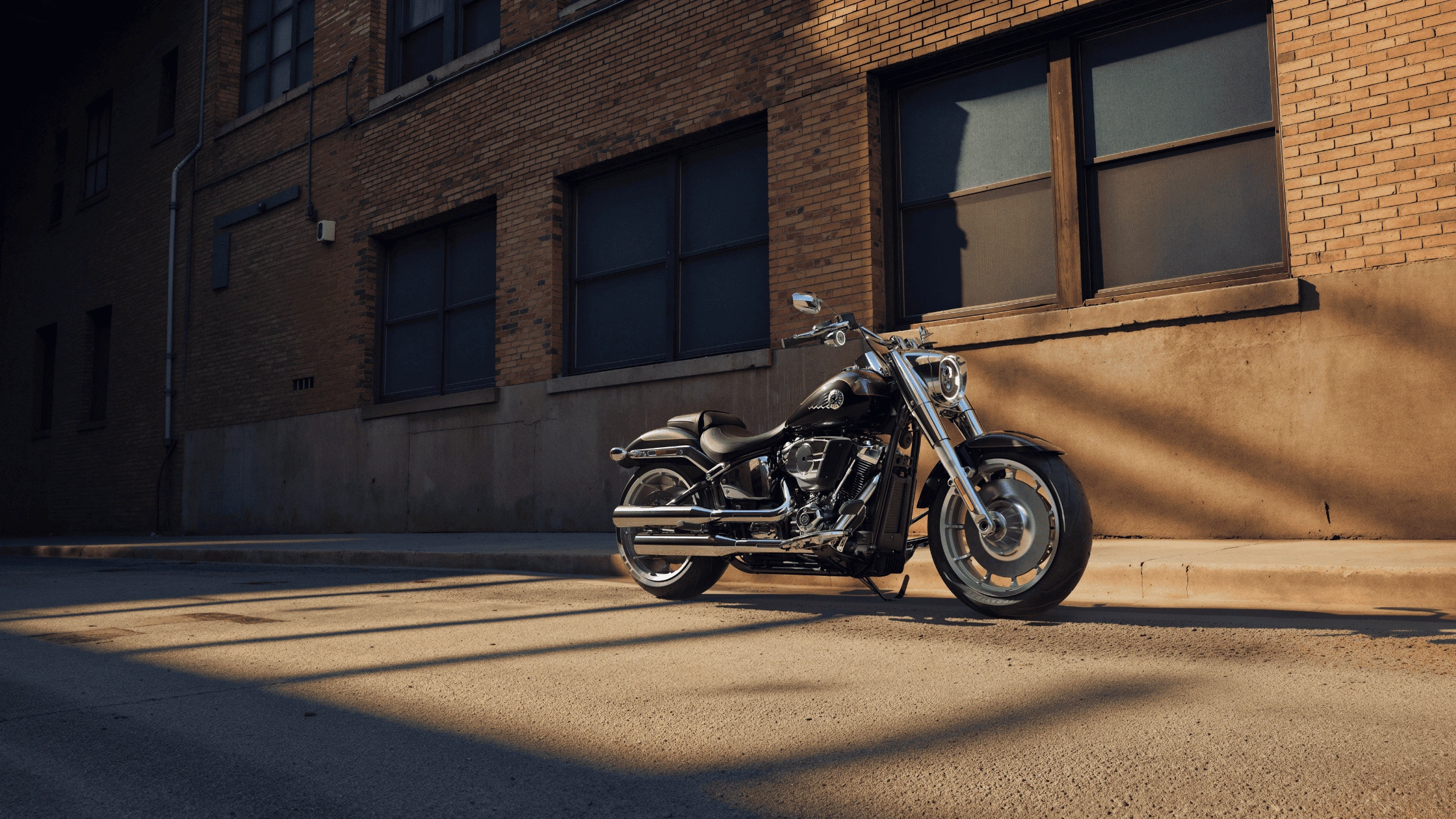 2026 Harley-Davidson Fat Boy in black parked on a sunlit urban street near Bentonville, AR.