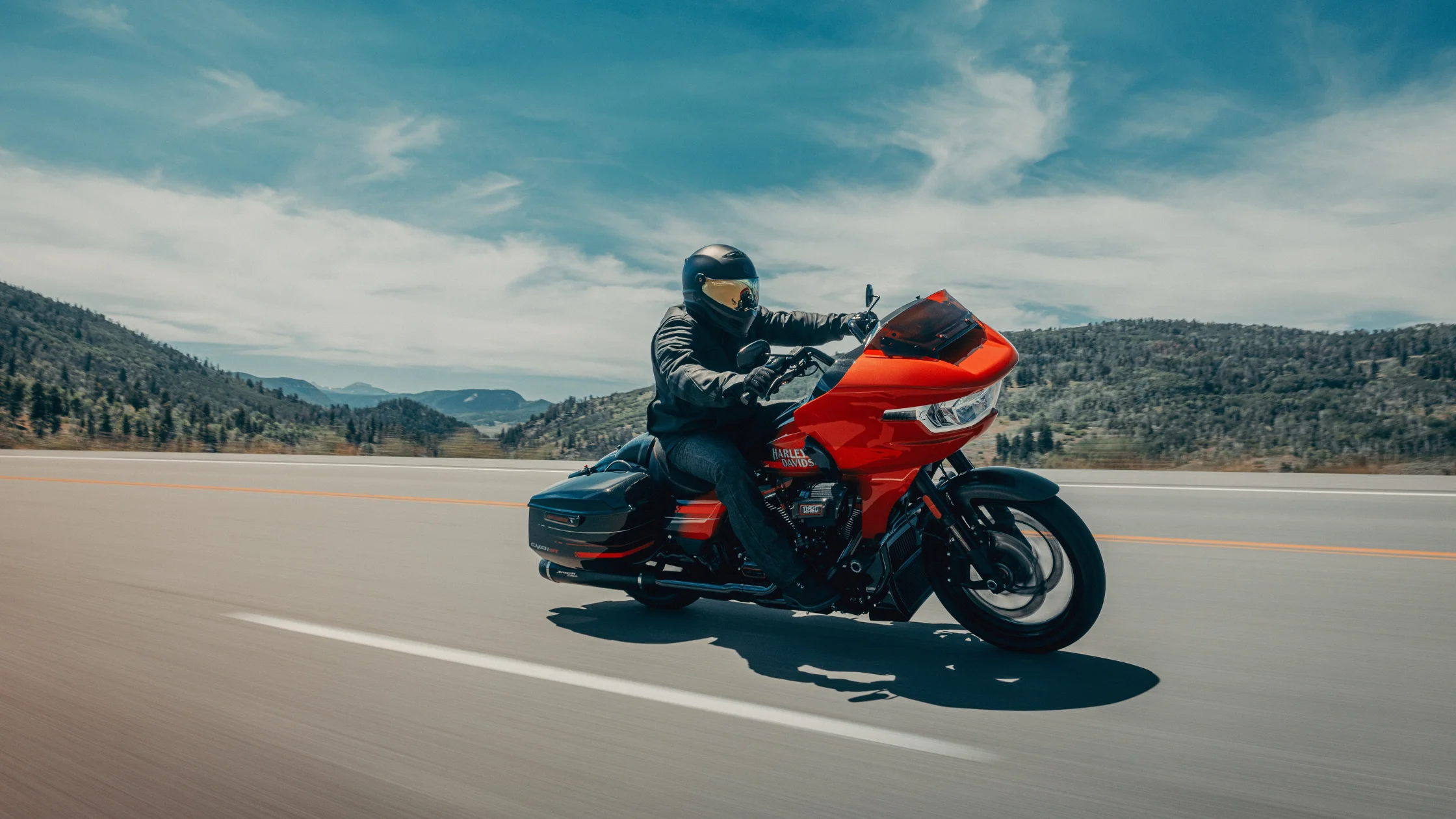 2026 Harley-Davidson® CVO™ Road Glide® ST riding on open highway with rider in full gear and aerodynamic fairing.