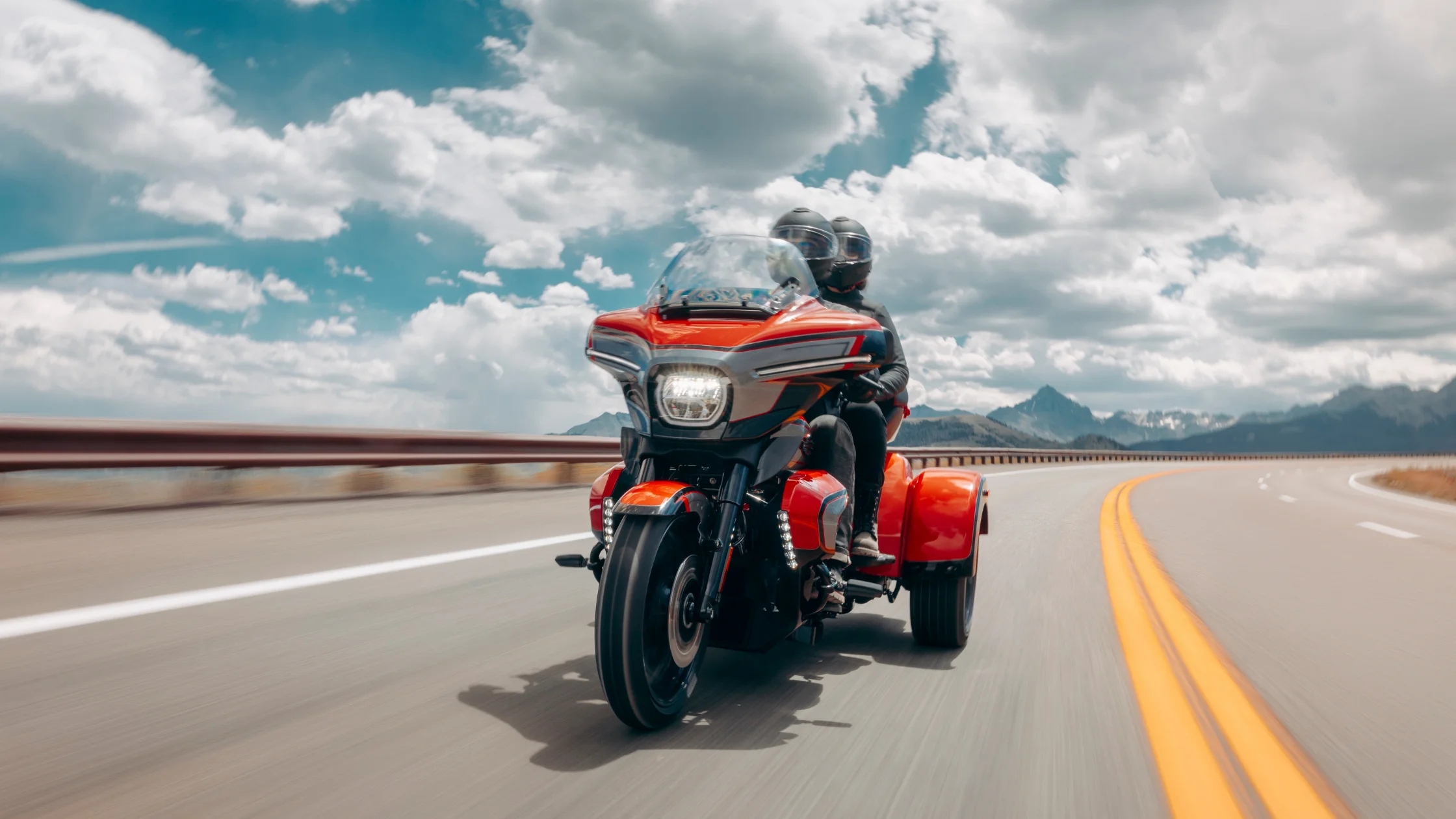 2026 Harley-Davidson® CVO™ Street Glide® 3 Limited touring trike riding on mountain road with two riders and front fairing.
