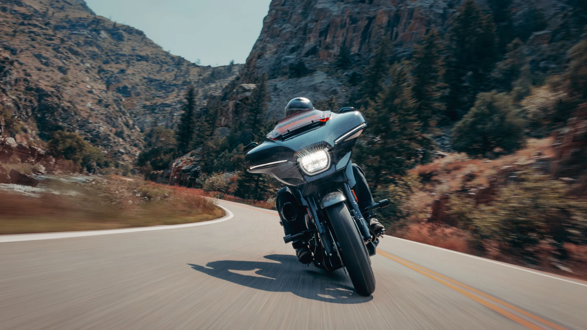 2026 Harley-Davidson® CVO™ Street Glide® ST leaning through canyon road with LED headlight and performance fairing.