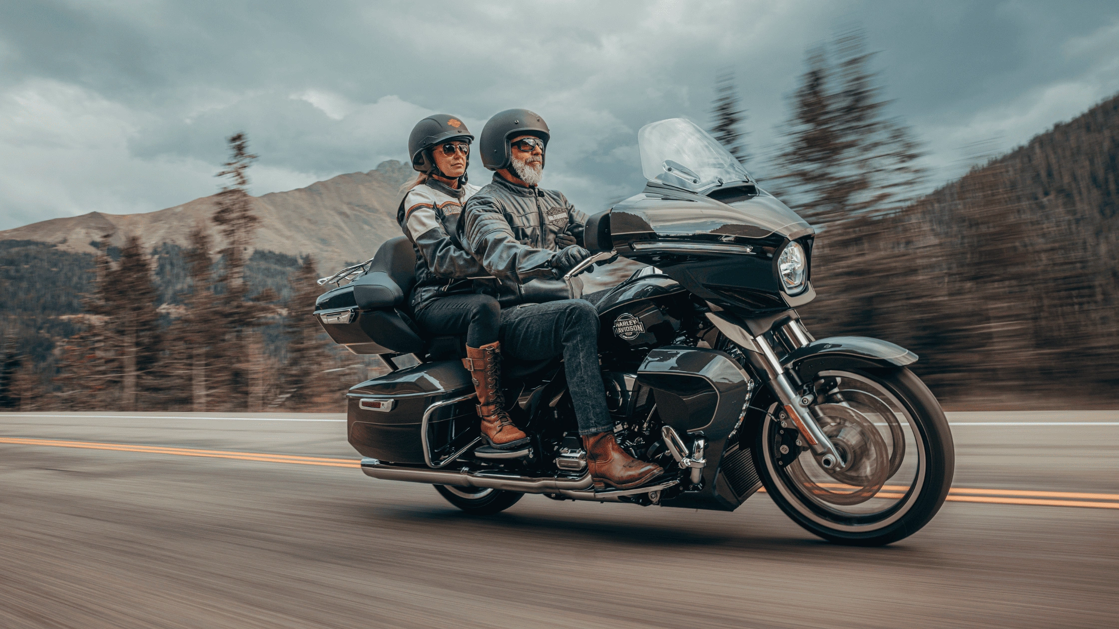 Couple riding a 2026 Harley-Davidson Street Glide Limited in black on a scenic mountain road, available in Baton Rouge LA