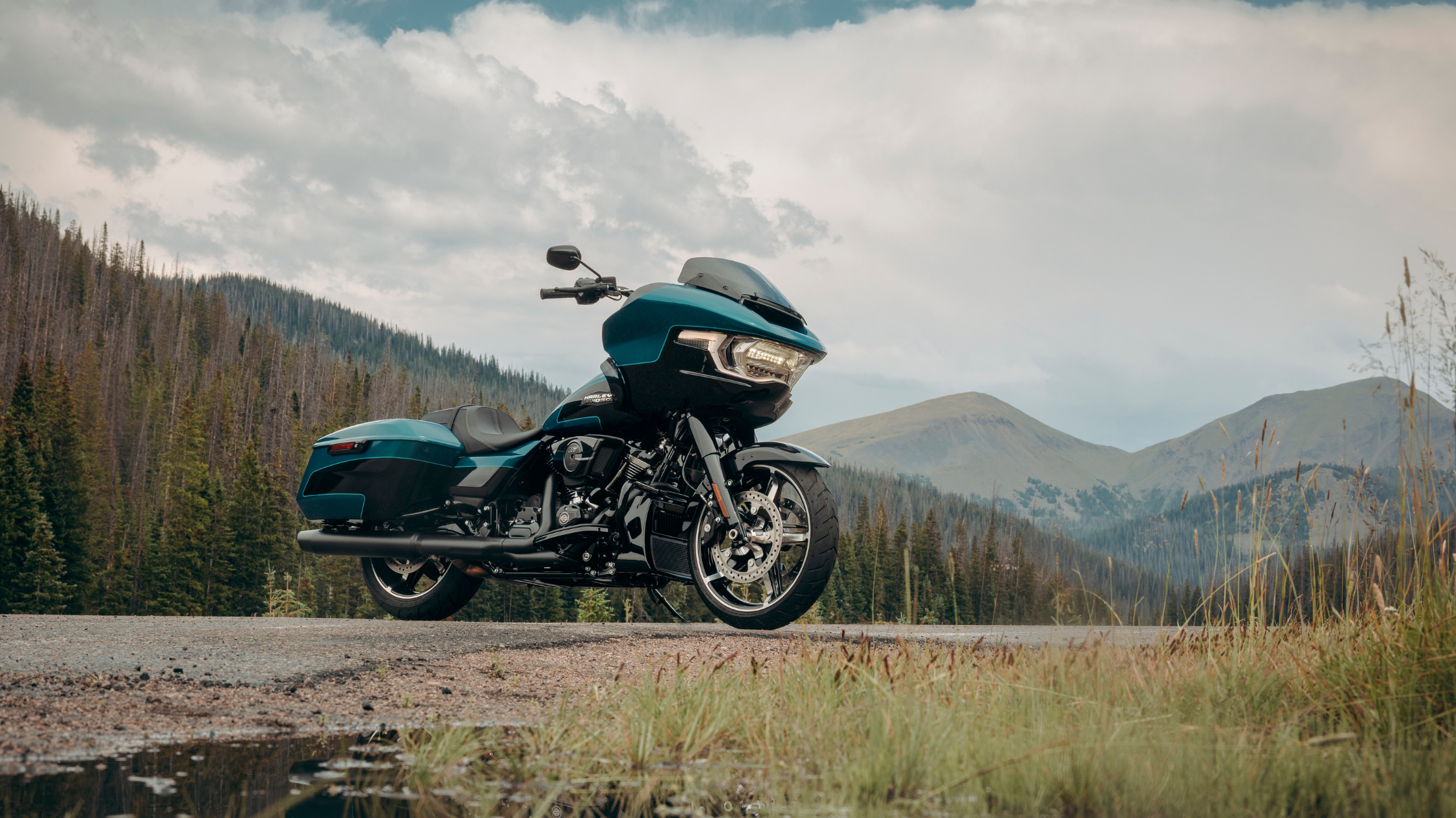 2026 Road Glide® motorcycle parked near a mountain road with scenic alpine views