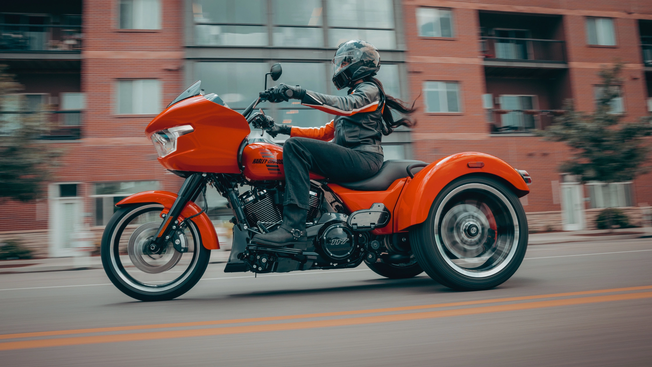 2026 Harley-Davidson® Road Glide® 3 trike riding through a city street with motion blur