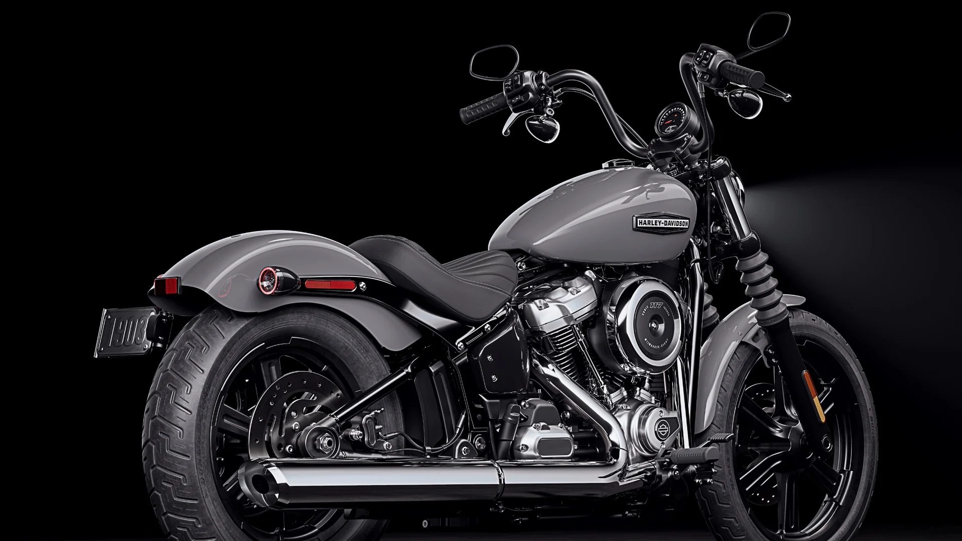 2026 Street Bob® red cruiser motorcycle parked on city street with side profile and chrome exhaust.